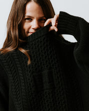 Close-up of traditional cable knit and integrated SL initials on the Black Aran Jumper