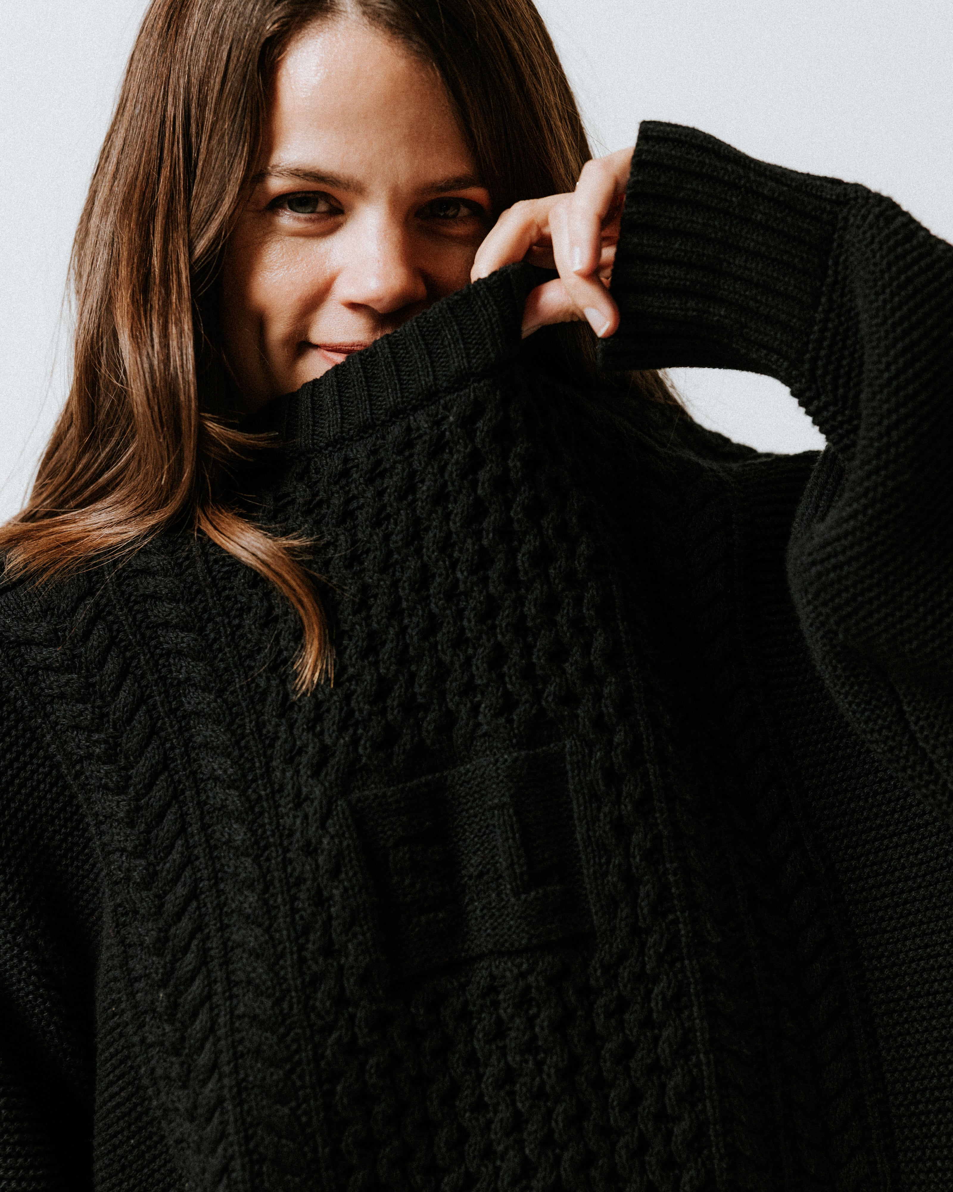 Close-up of traditional cable knit and integrated SL initials on the Black Aran Jumper