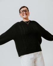Model wearing the black 100% cotton Aran Jumper by Slow Love Knitwear