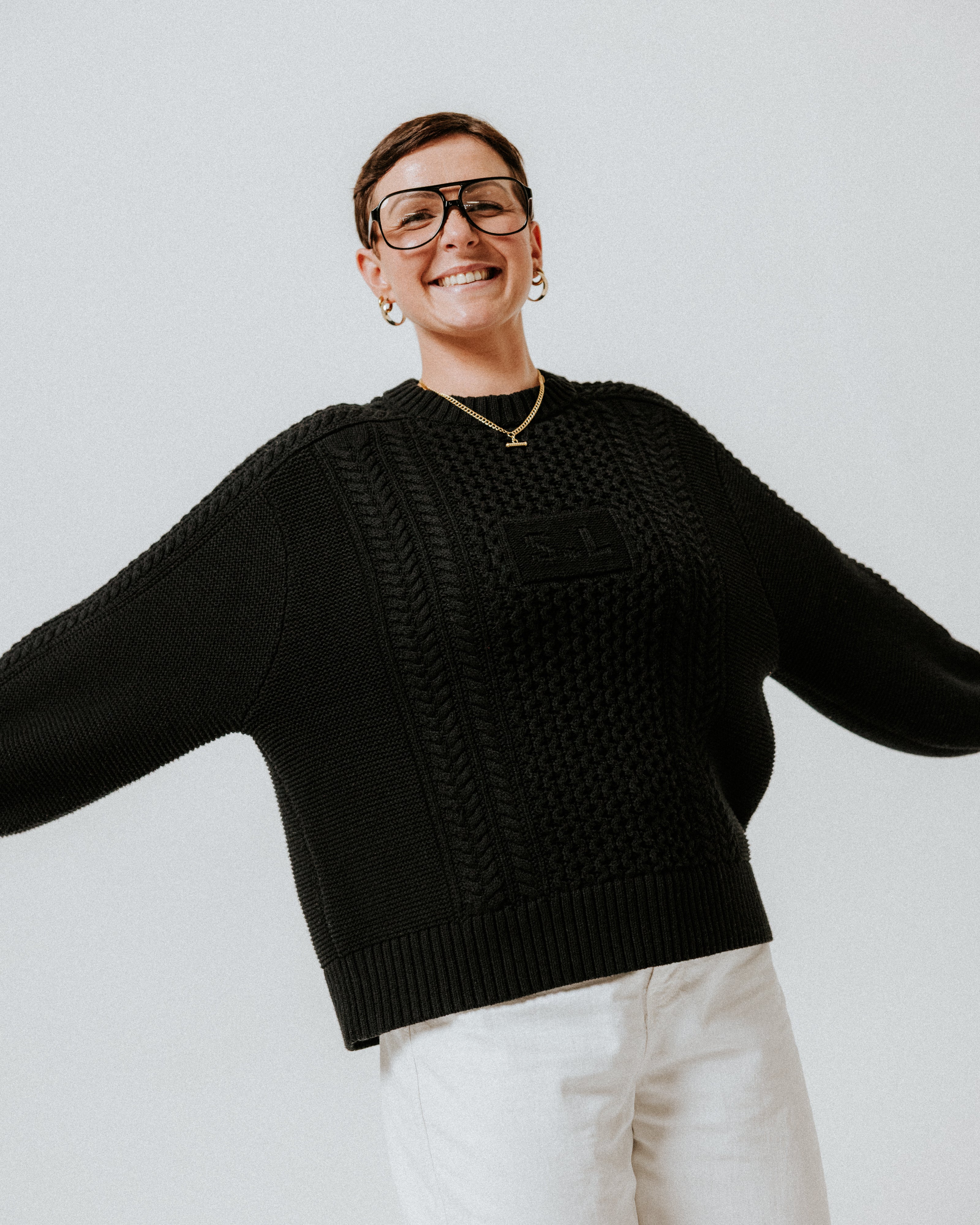 Model wearing the black 100% cotton Aran Jumper by Slow Love Knitwear