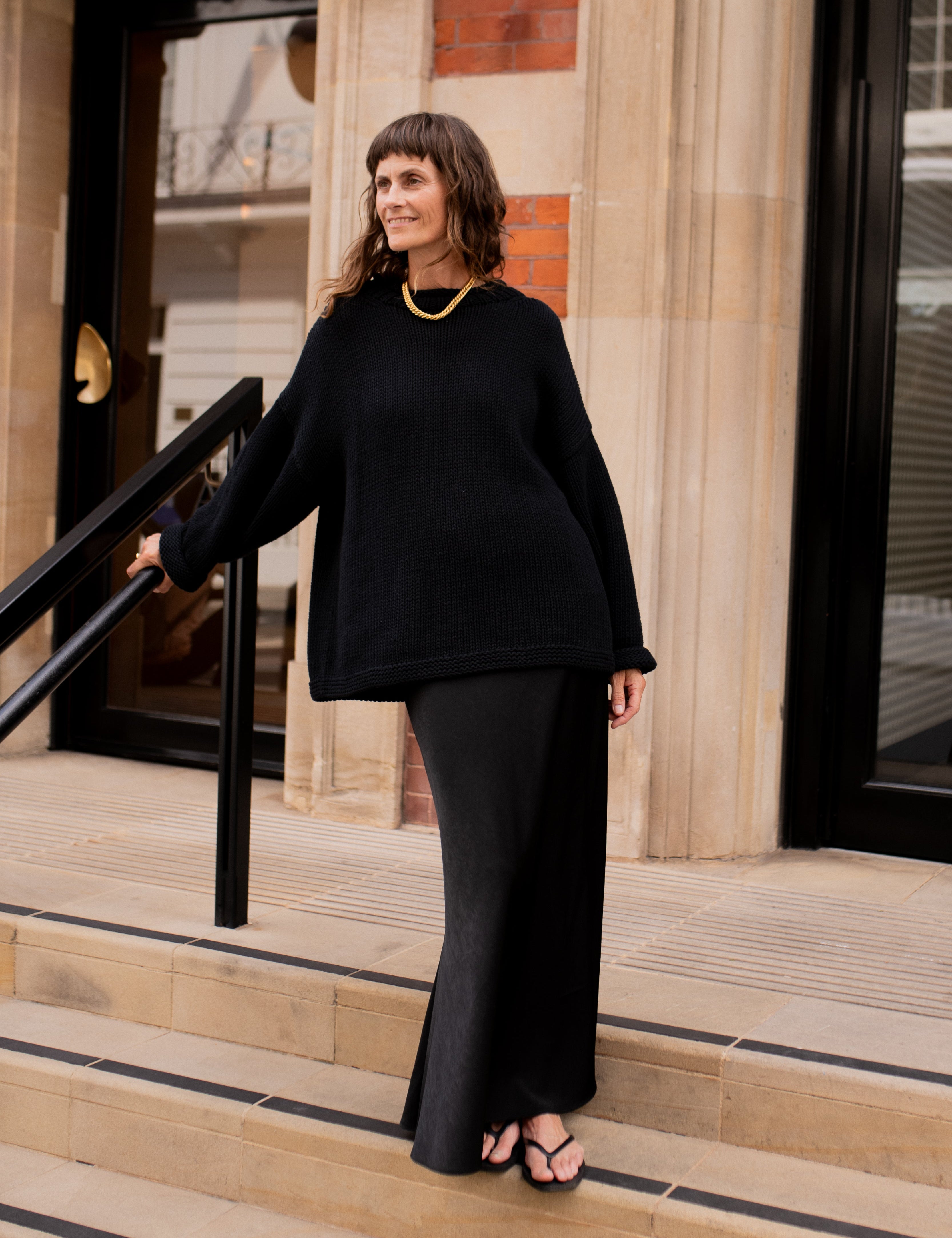 Lifestyle image of black hand knit jumper styled casually