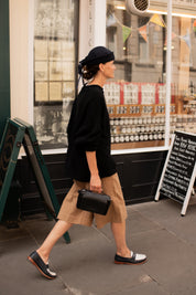 Side view of model wearing black oversized cotton jumper
