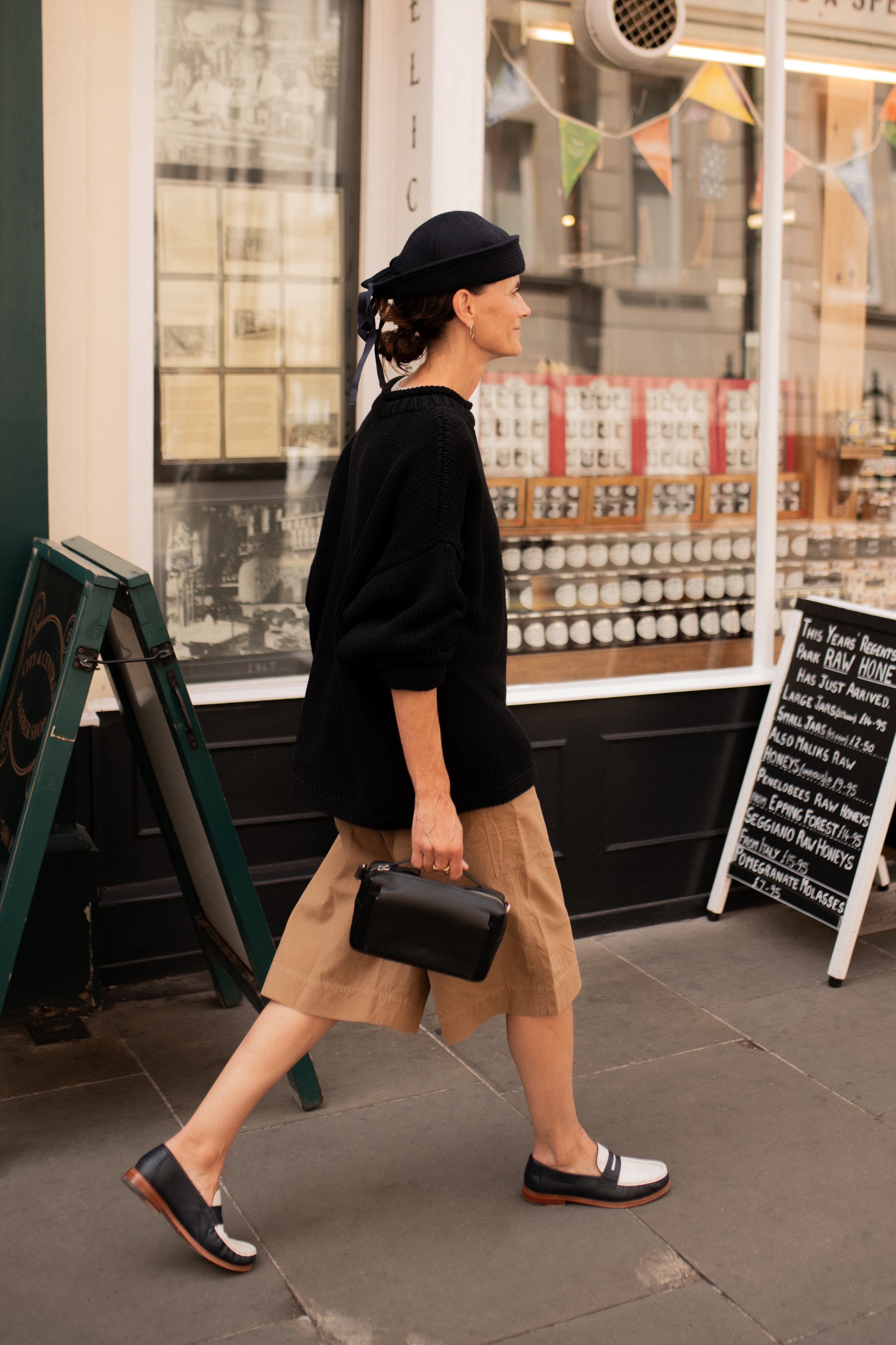 Side view of model wearing black oversized cotton jumper