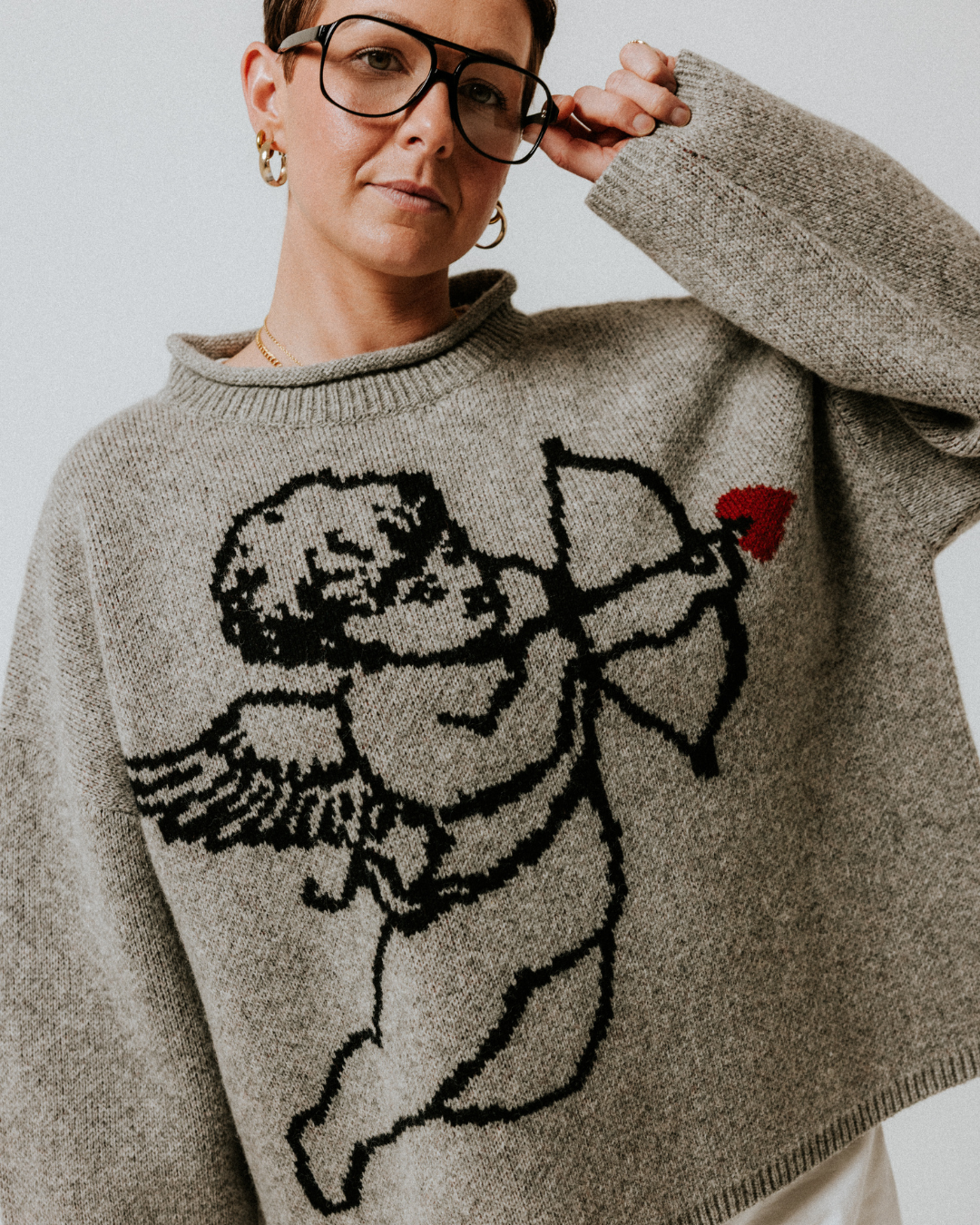 Slow Love grey Cherub Jumper showcasing its signature cherub motif and soft lambswool knit.