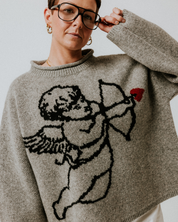 Slow Love grey Cherub Jumper showcasing its signature cherub motif and soft lambswool knit.