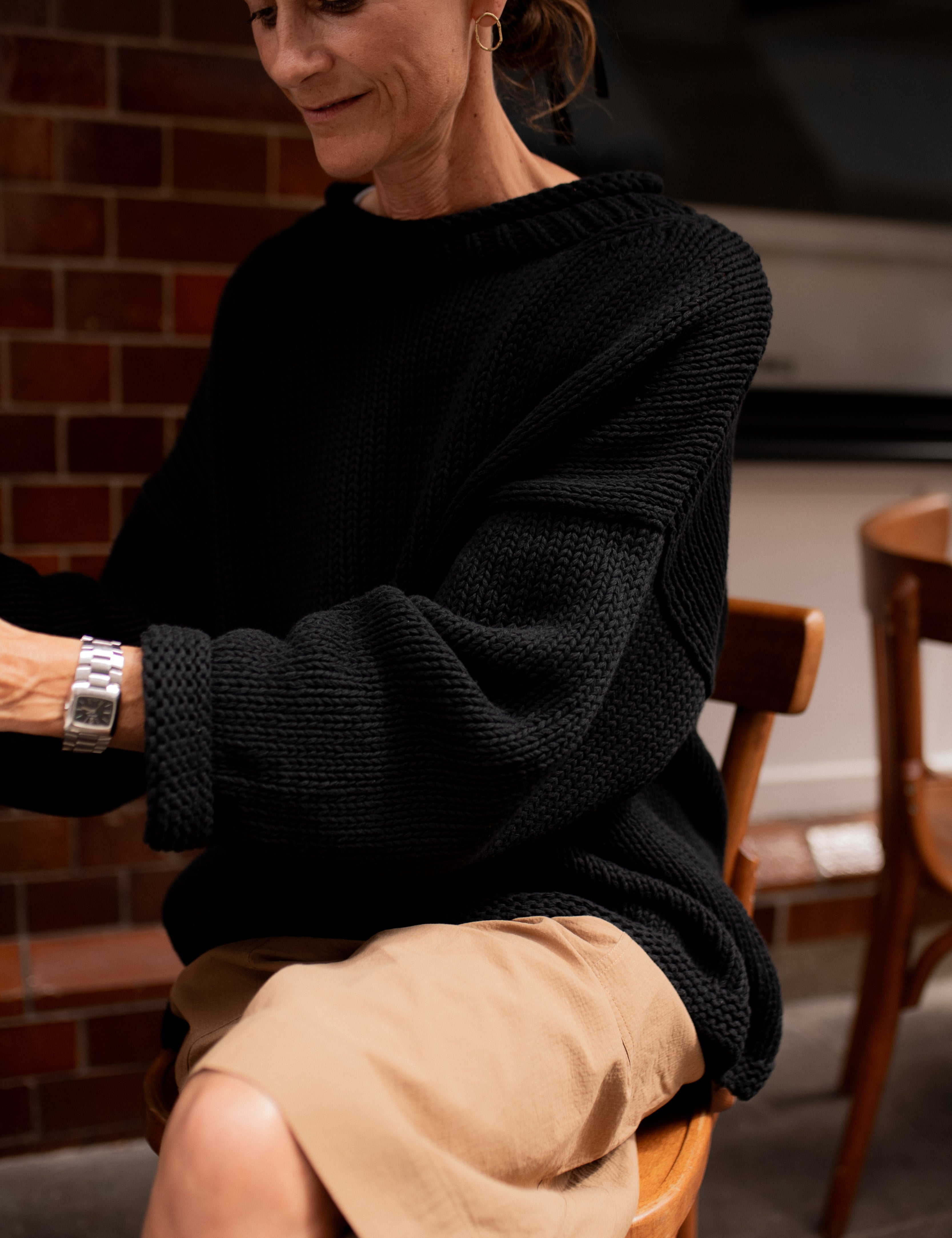 Sleeve detail of chunky black hand knit jumper