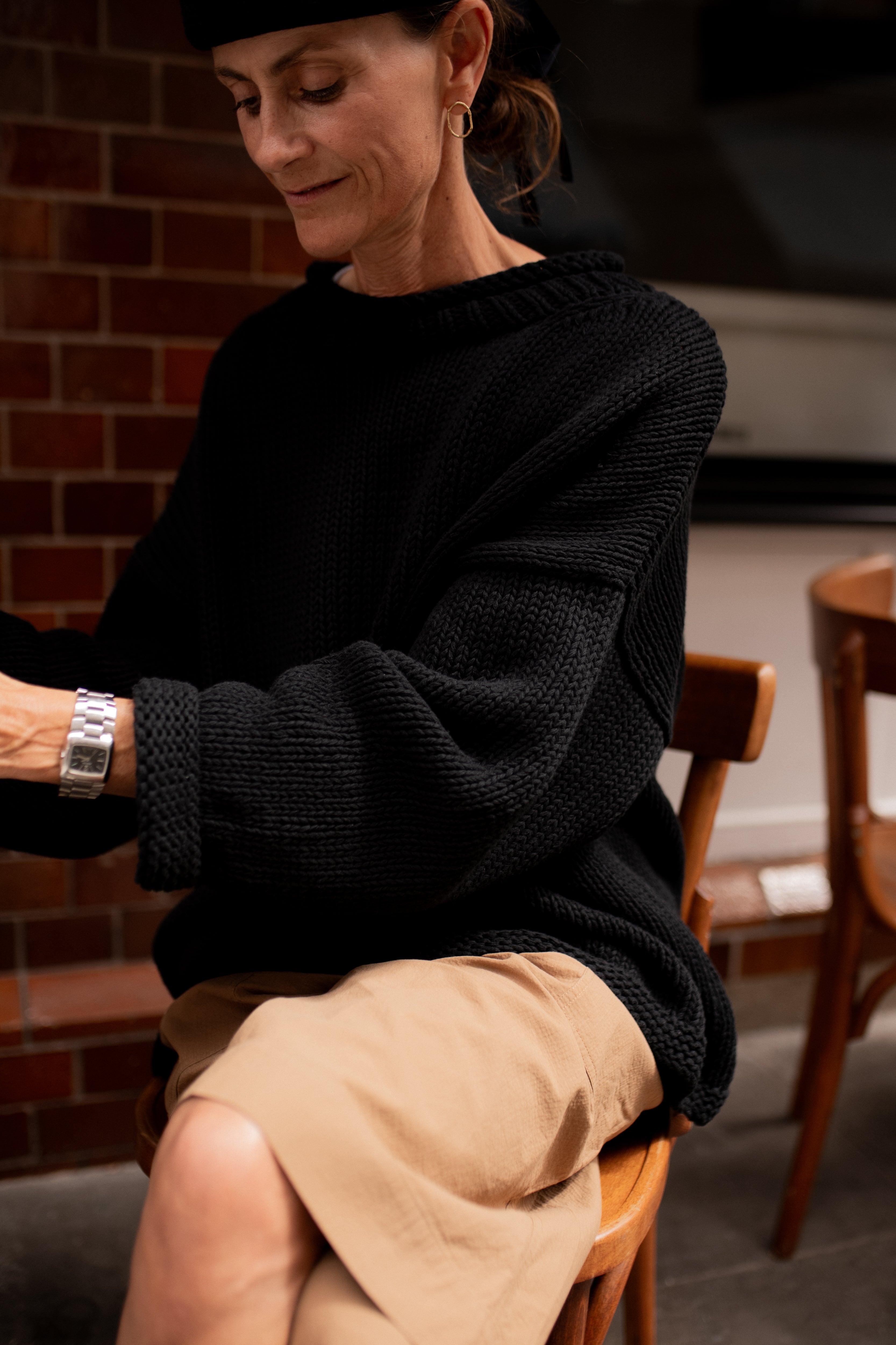 Sleeve detail of chunky black hand knit jumper