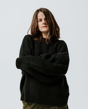 Model wearing the black 100% cotton Aran Jumper by Slow Love Knitwear