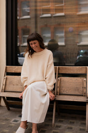 Model wearing cream hand knit jumper styled from the front