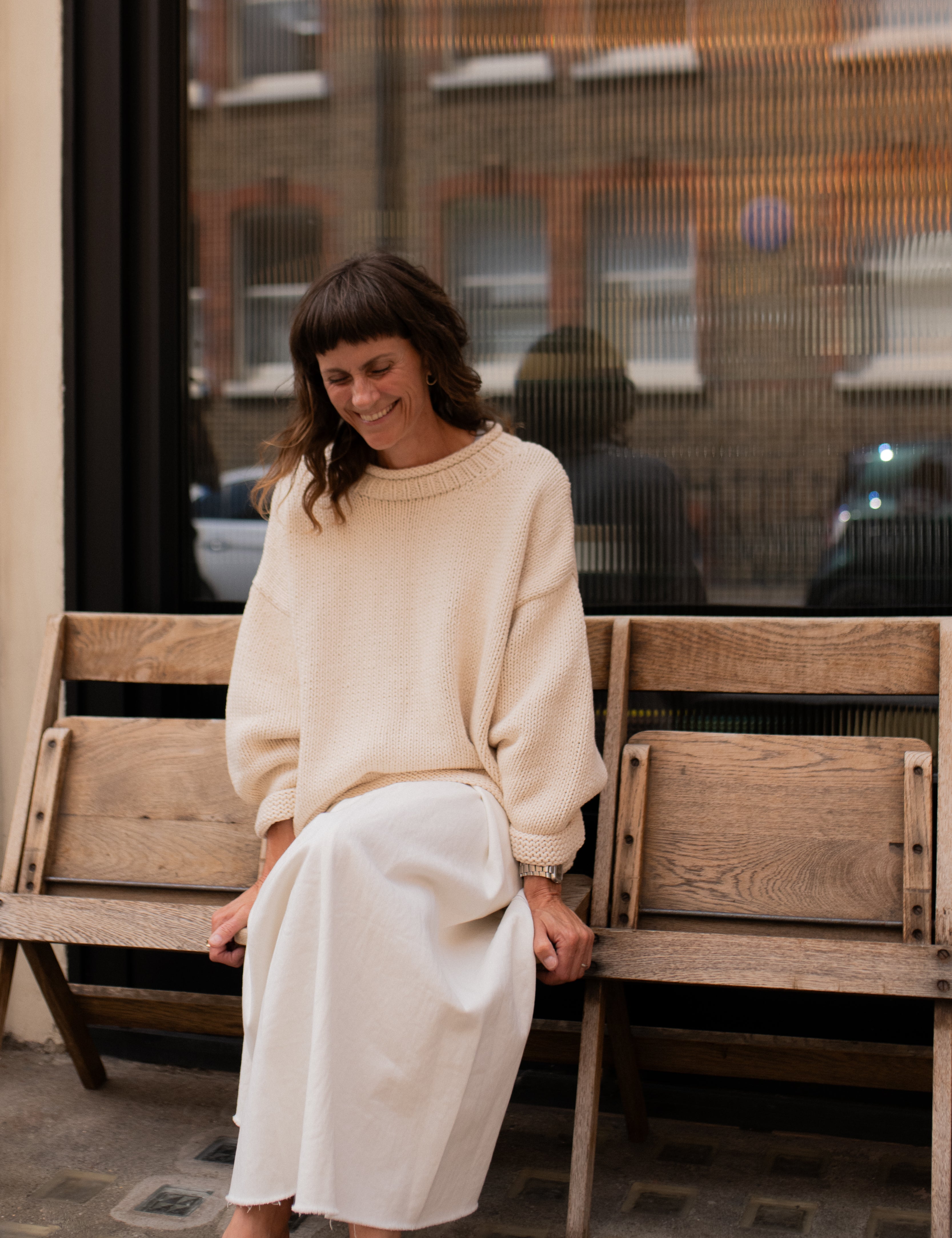 Model wearing cream hand knit jumper styled from the front