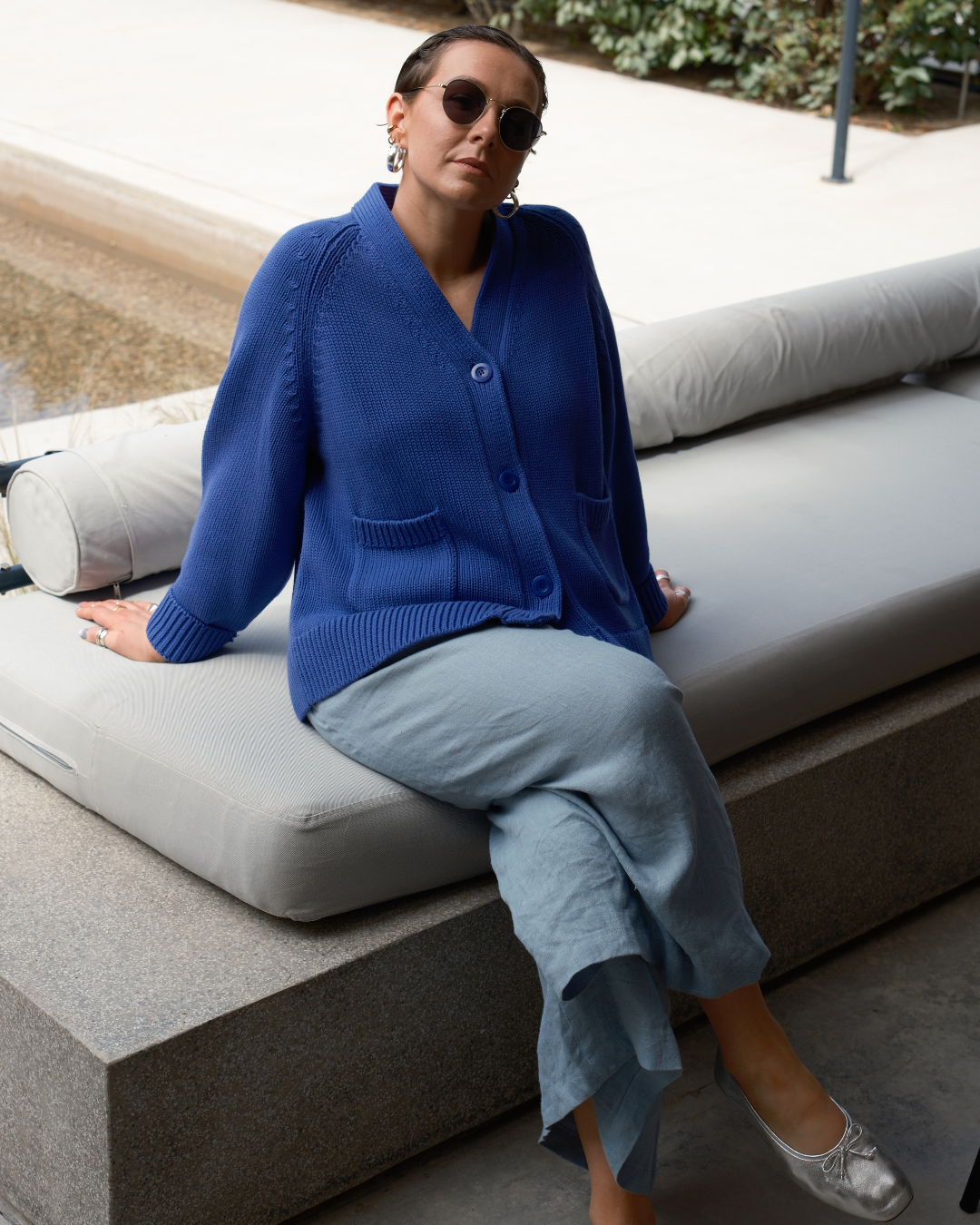 Faded indigo cotton knit cardigan with relaxed oversized silhouette and playful smiley motif