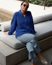 Faded indigo cotton knit cardigan with relaxed oversized silhouette and playful smiley motif