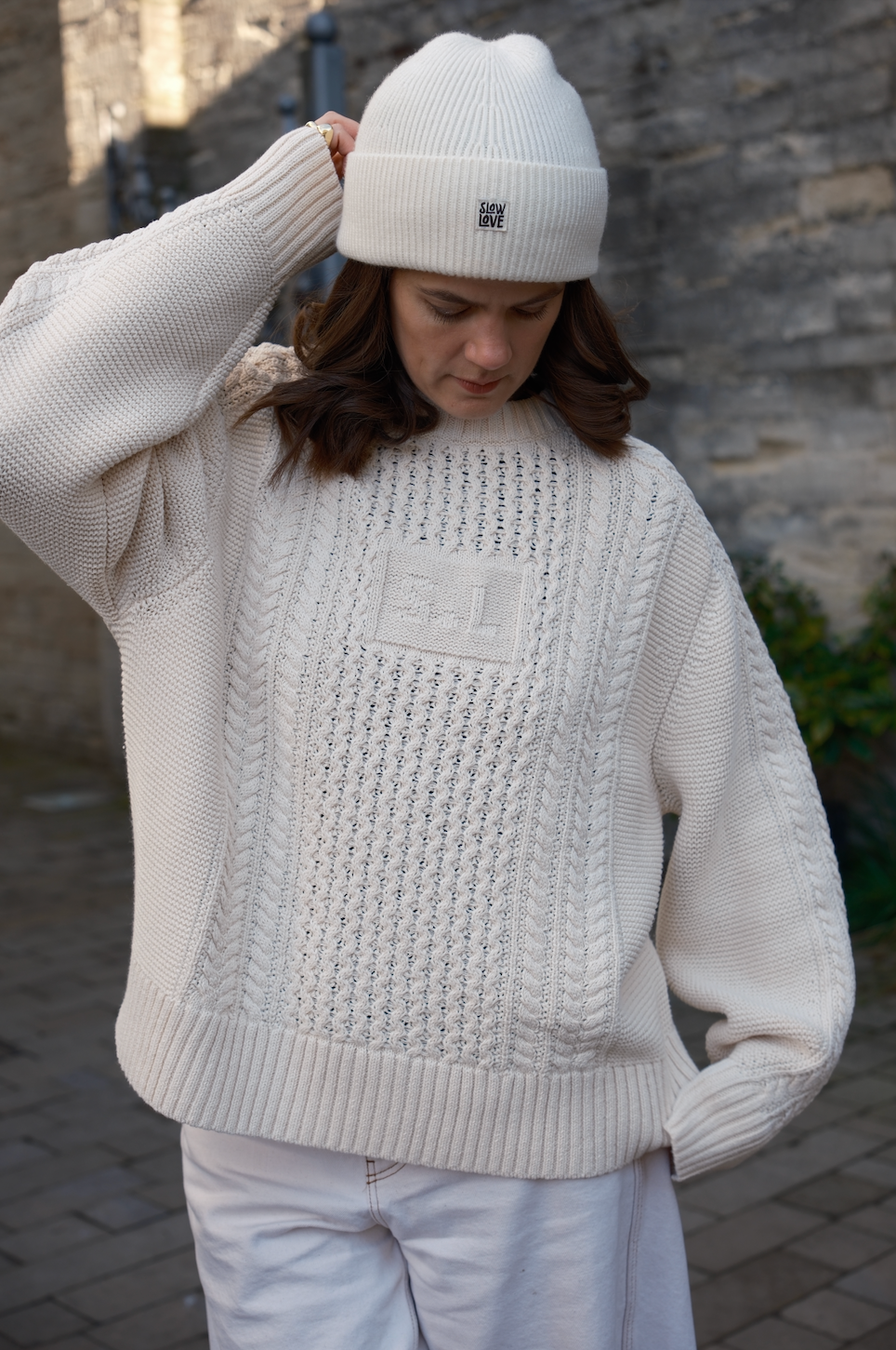 Close-up of traditional cable knit and integrated SL initials on the Oat Milk Aran Jumper
