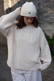 Close-up of traditional cable knit and integrated SL initials on the Oat Milk Aran Jumper