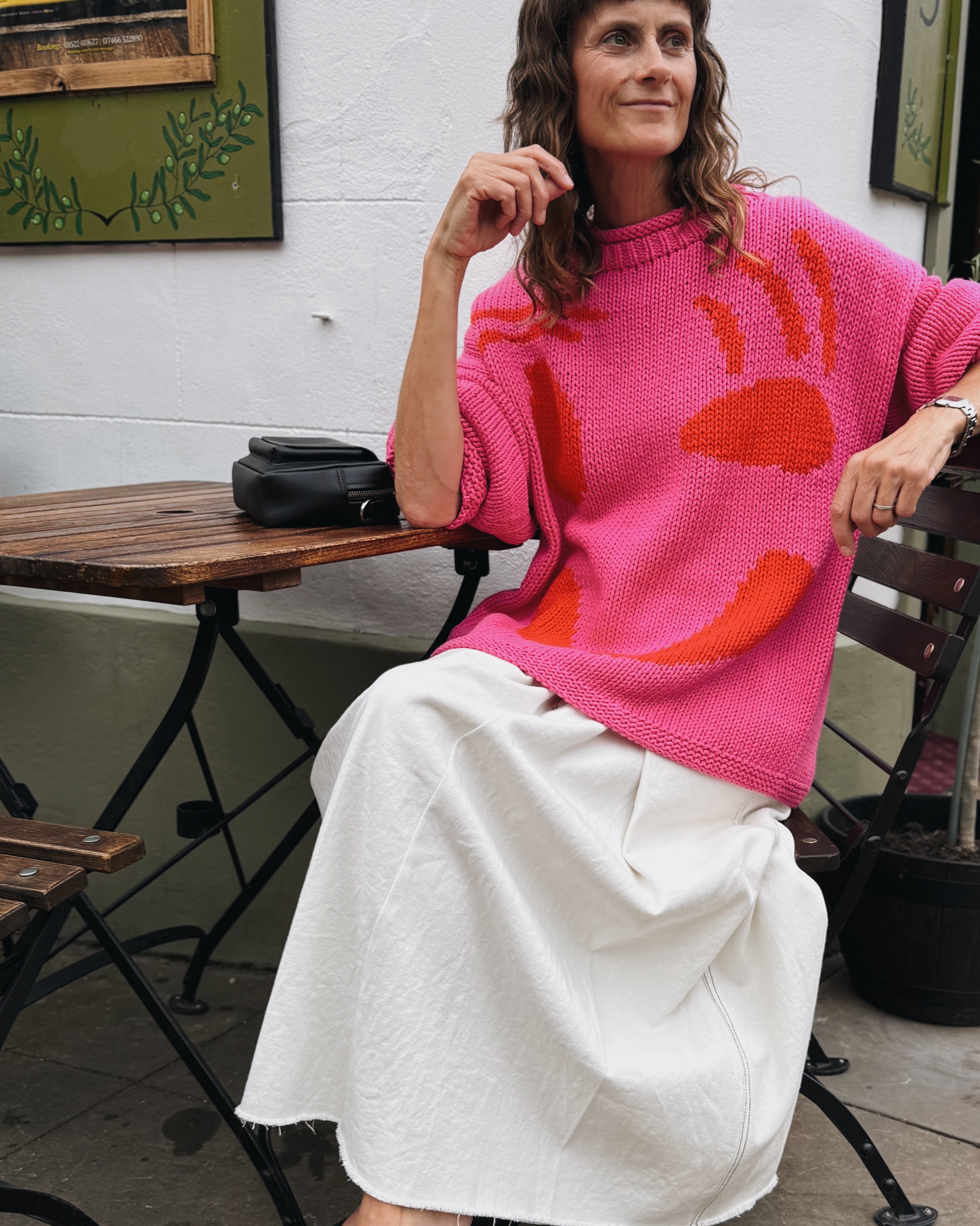 Full length view of oversized pink and red cotton jumper on model