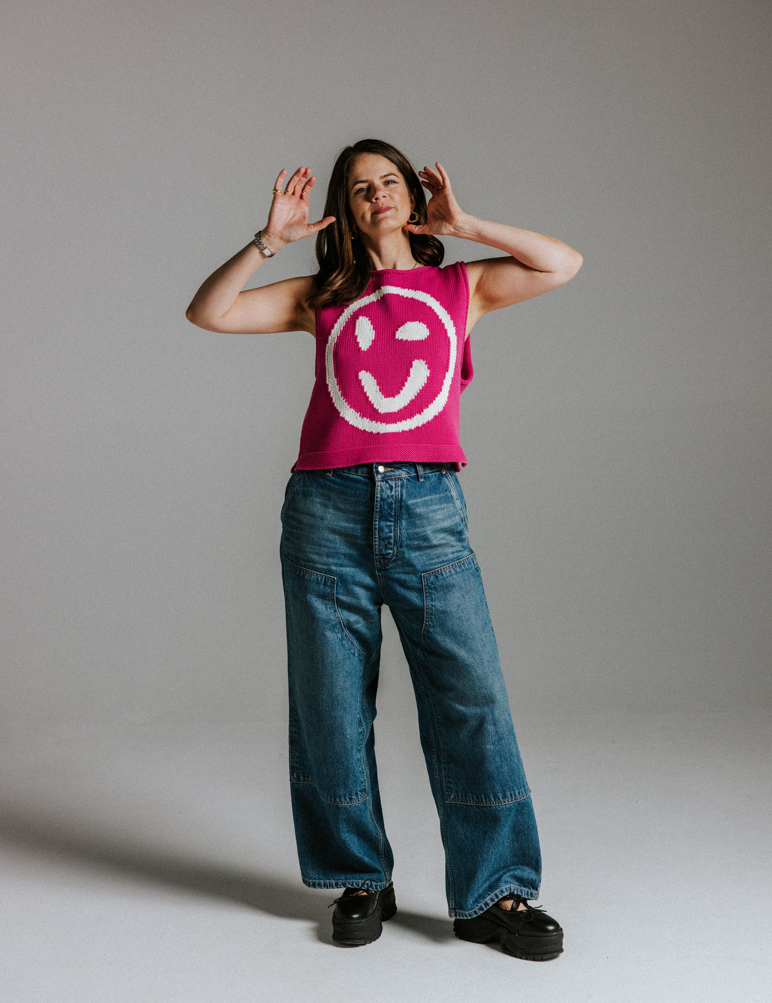 Front view of pink and white cotton knit tank top with smiley face detail by Slow Love Knitwear