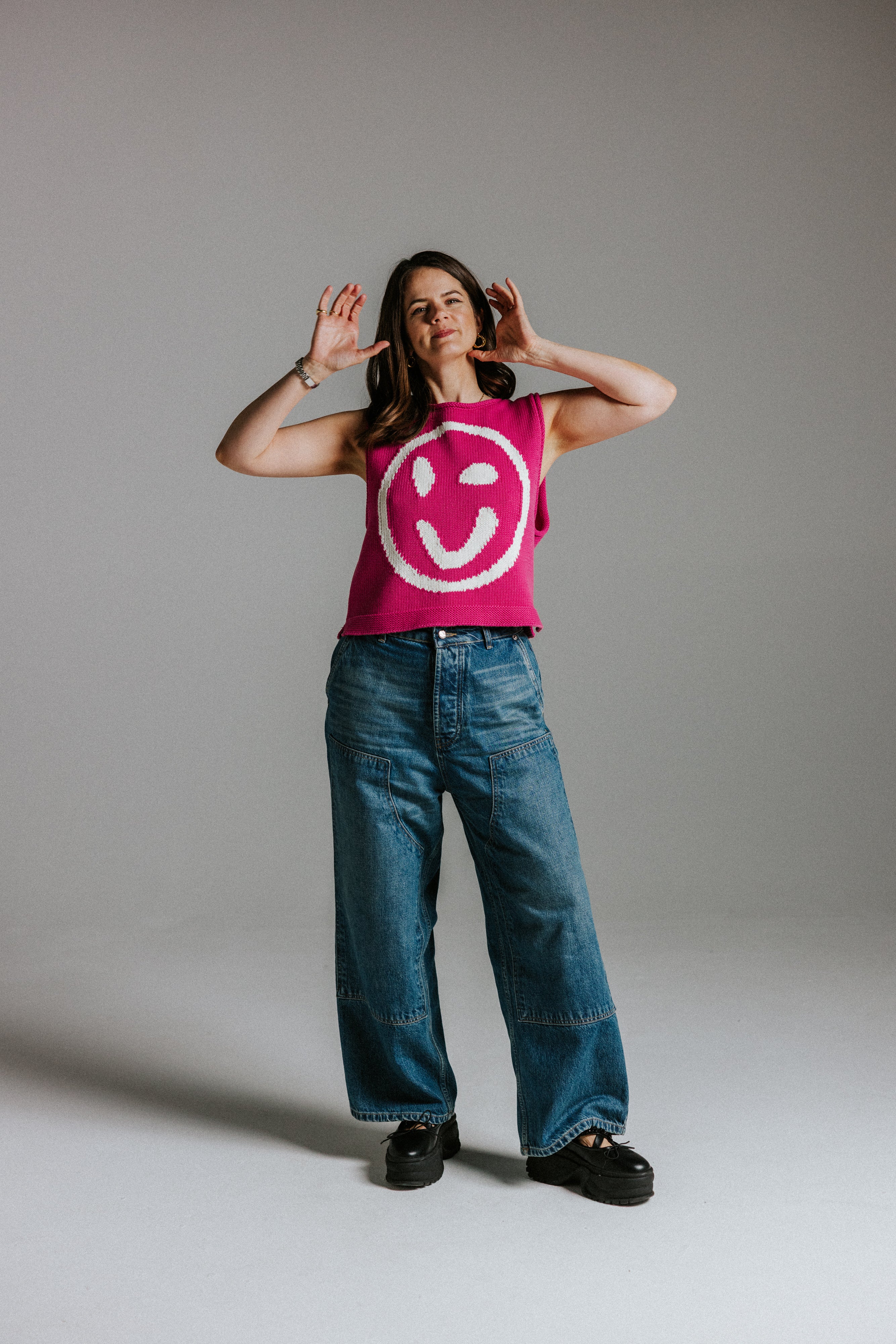 Front view of pink and white cotton knit tank top with smiley face detail by Slow Love Knitwear