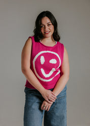 Lifestyle image of model wearing pink and white smiley face cotton knit tank top