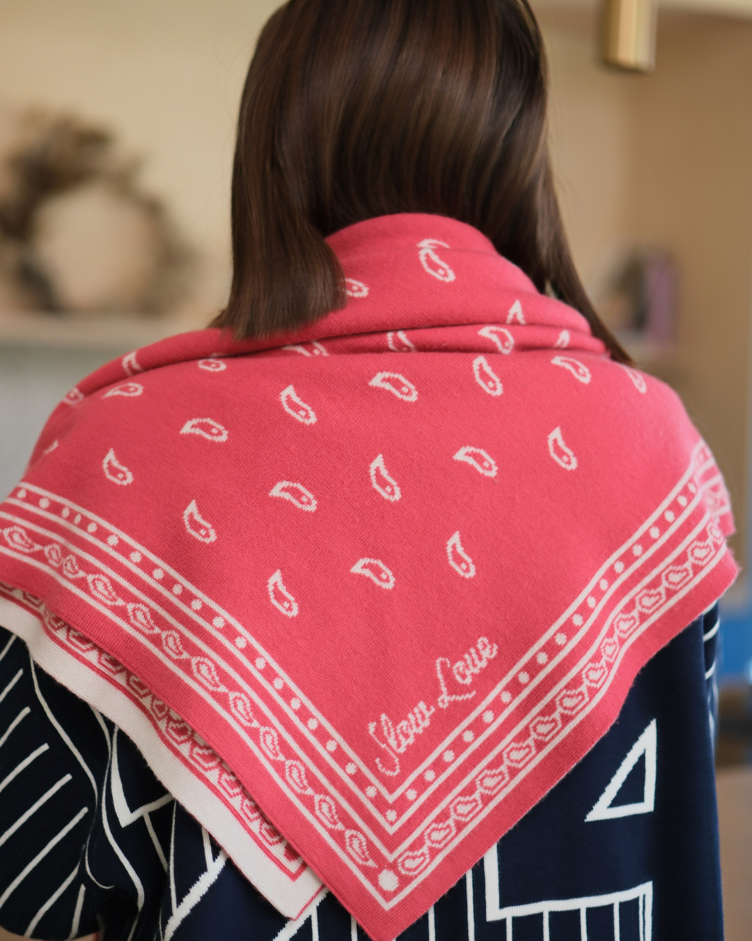 Slow Love red knitted bandana scarf styled as a cosy neck accessory, made from 100% luxury merino wool.