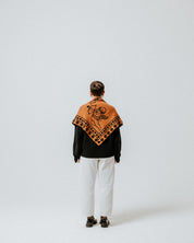 The Slow Love Cherub Scarf in toffee and black, knitted from 100% merino wool with a distinctive cherub design.