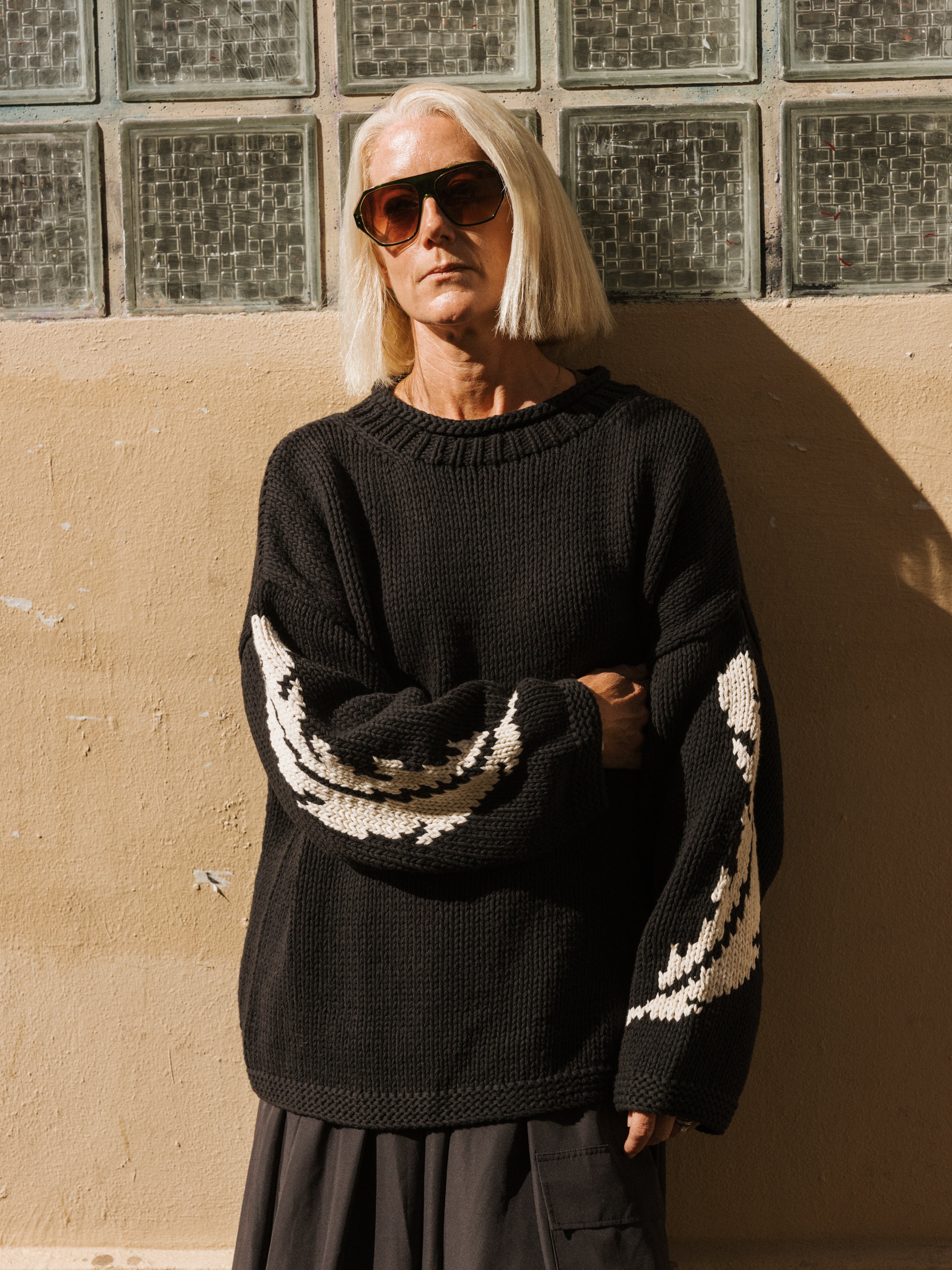 Close-up of the feather motif detailing on The Slow Love Feather Hand Knit Jumper, highlighting its chunky knitted texture.