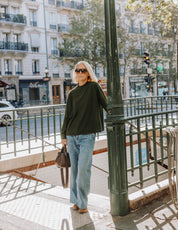 Model wearing The Slow Love khaki merino wool turtle neck jumper, showcasing its lightweight knit and classic silhouette.