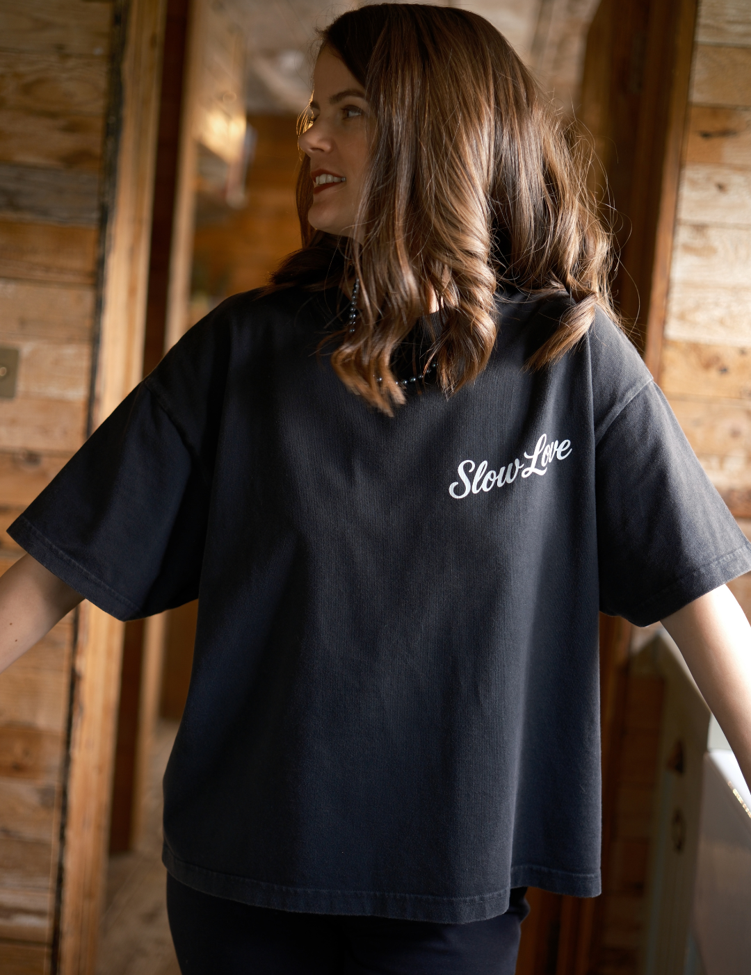 Model wearing Slow Love Studio faded black oversized boxy t-shirt with relaxed fit.