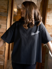 Model wearing Slow Love Studio faded black oversized boxy t-shirt with relaxed fit.