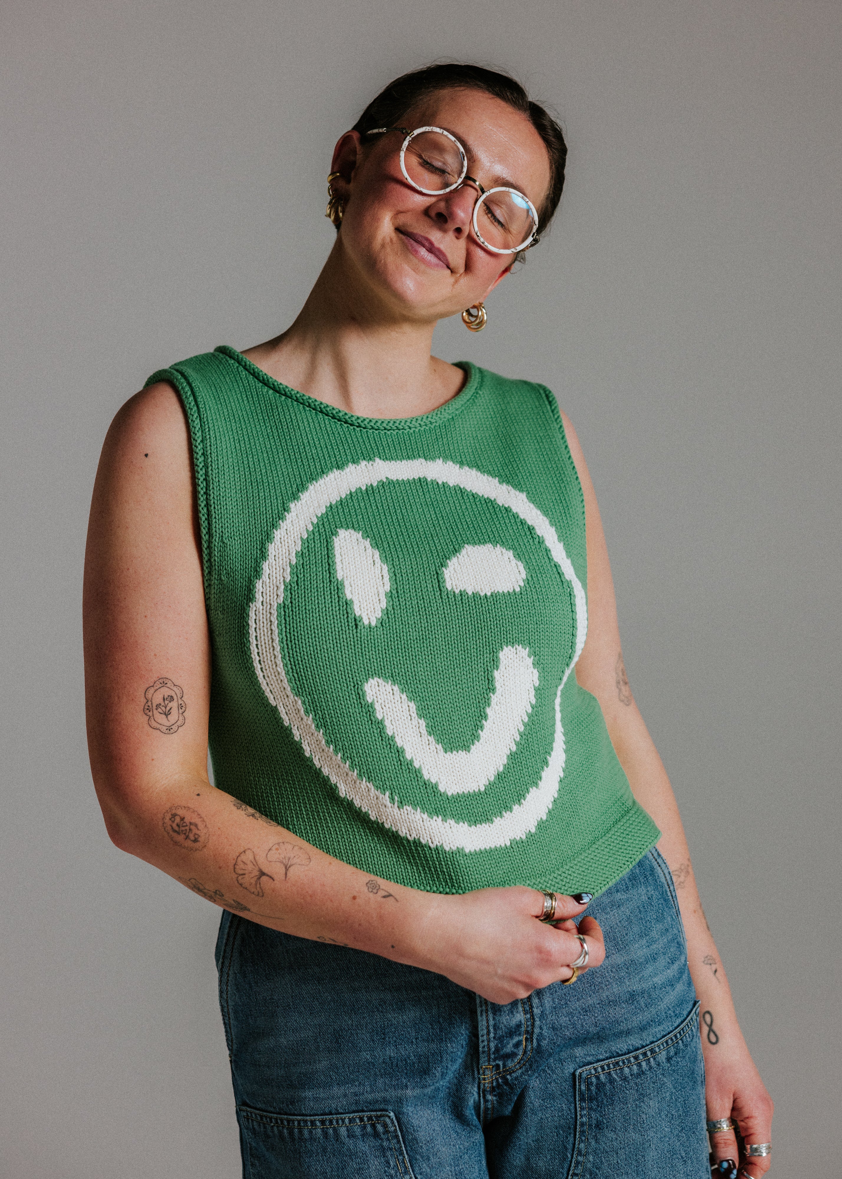 Green and white cotton knit tank top by Slow Love Knitwear with smiley face motif and boxy fit