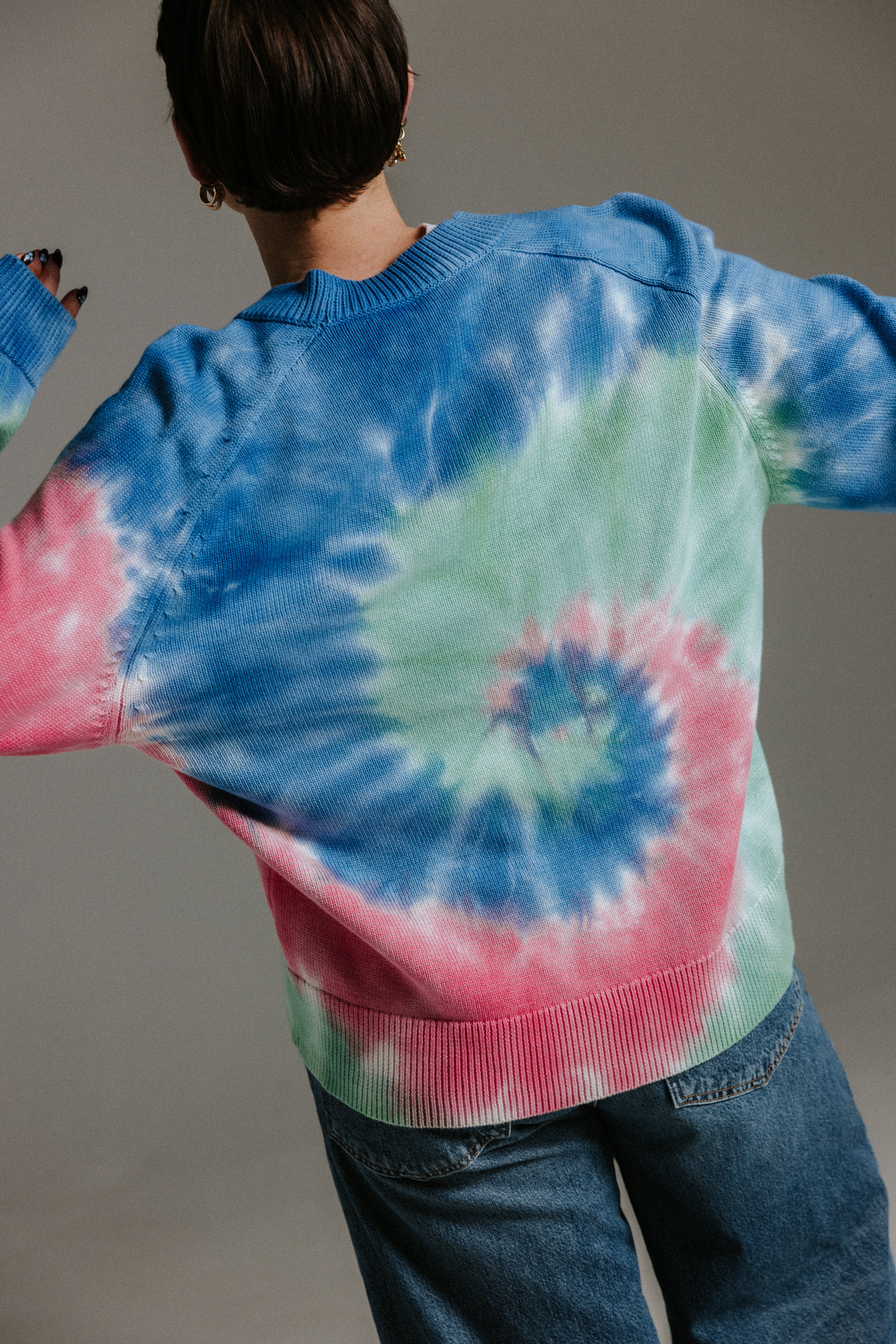 Back view of hand tie-dyed cotton cardigan by Slow Love Knitwear with unique sun-washed colour pattern