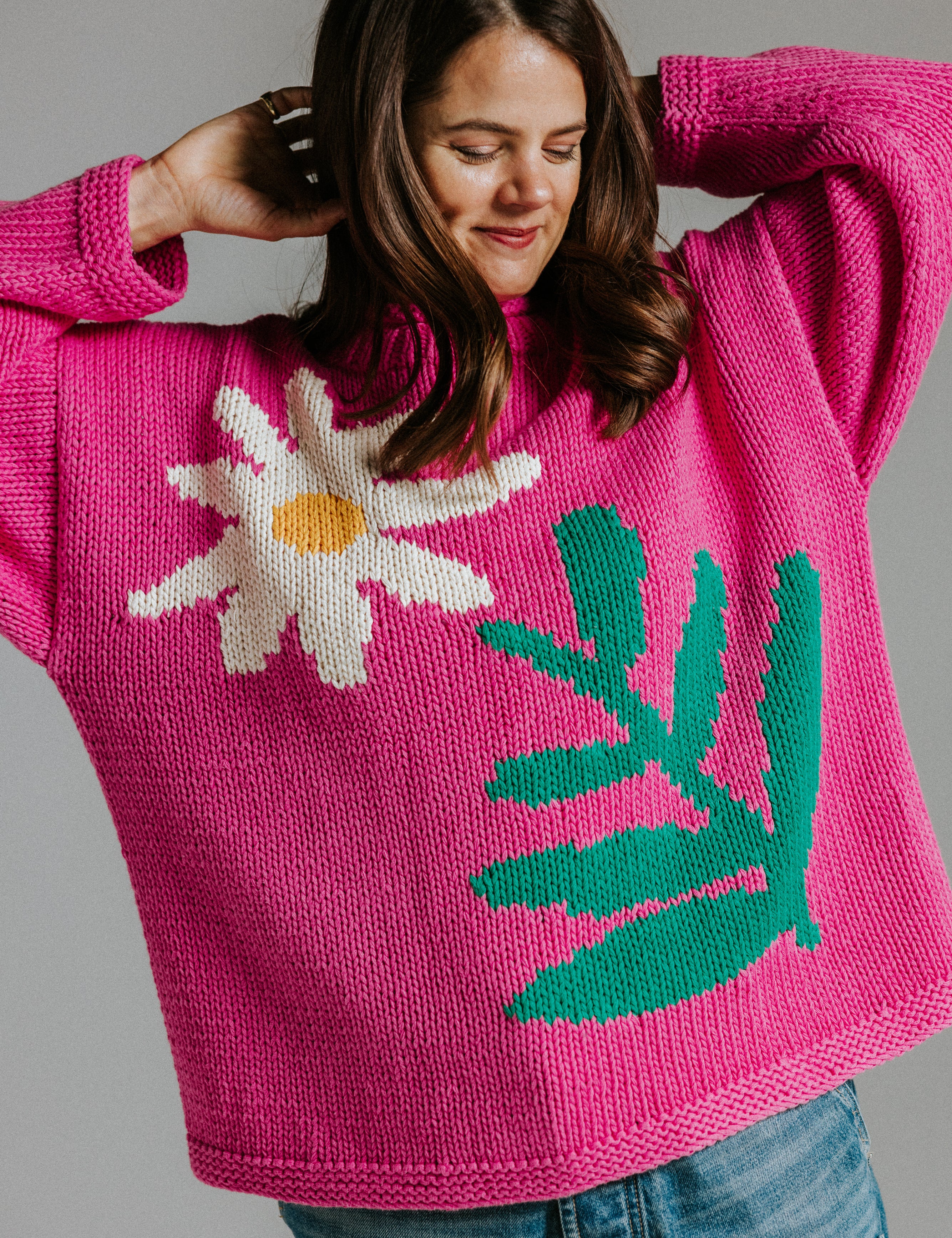Hand knitted cotton jumper by Slow Love Knitwear with four colour intarsia daisy motif