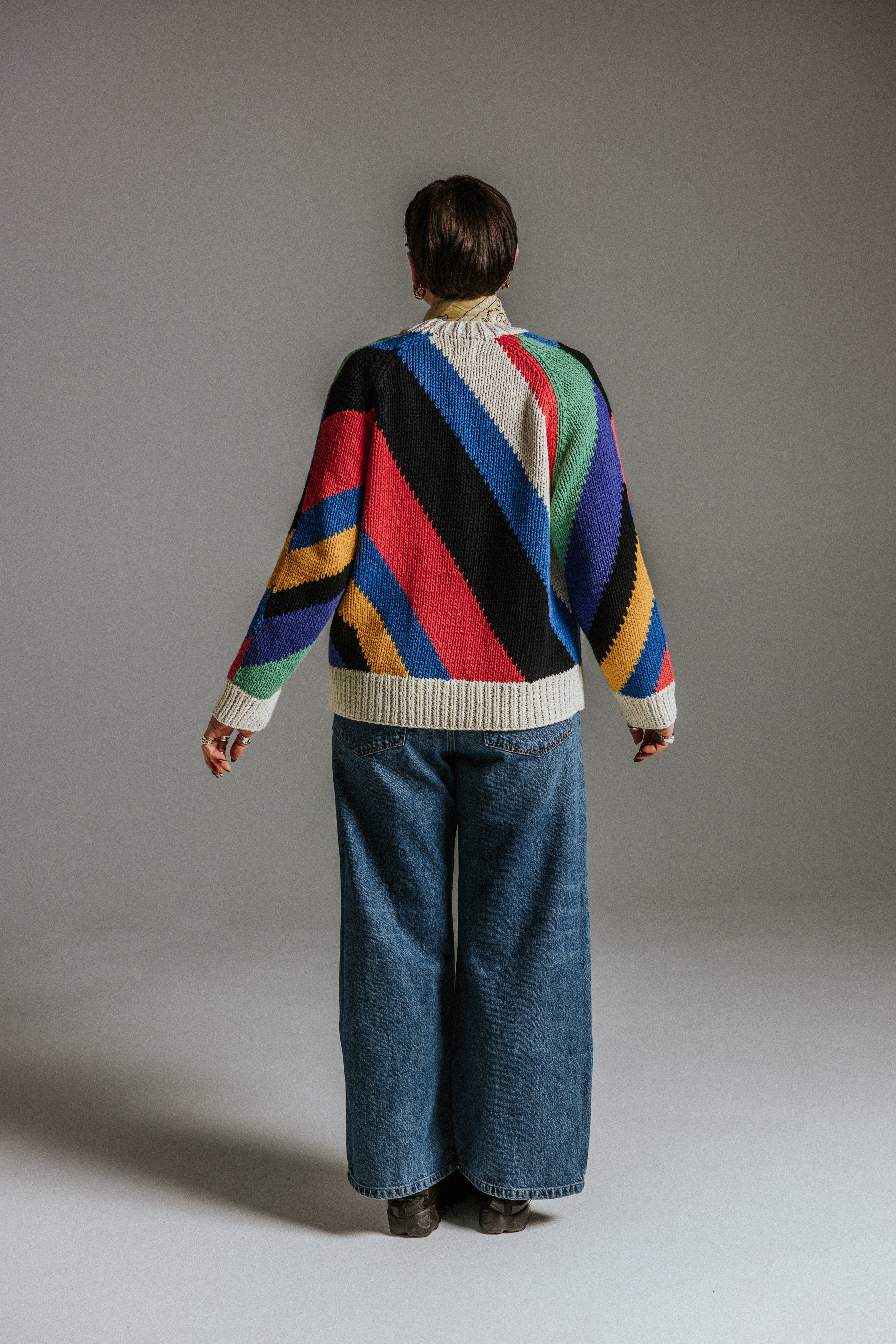 Back view of oversized handknit cotton cardigan with seven colour intarsia stripes by Slow Love Knitwear