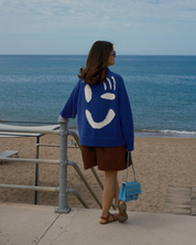 Relaxed grandad fit cardigan with statement white smiley face detail by Slow Love Knitwear