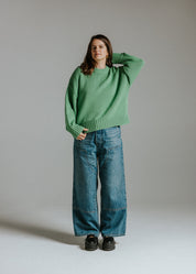 Model wearing oversized boxy cotton knit green jumper with balloon sleeves by Slow Love Knitwear