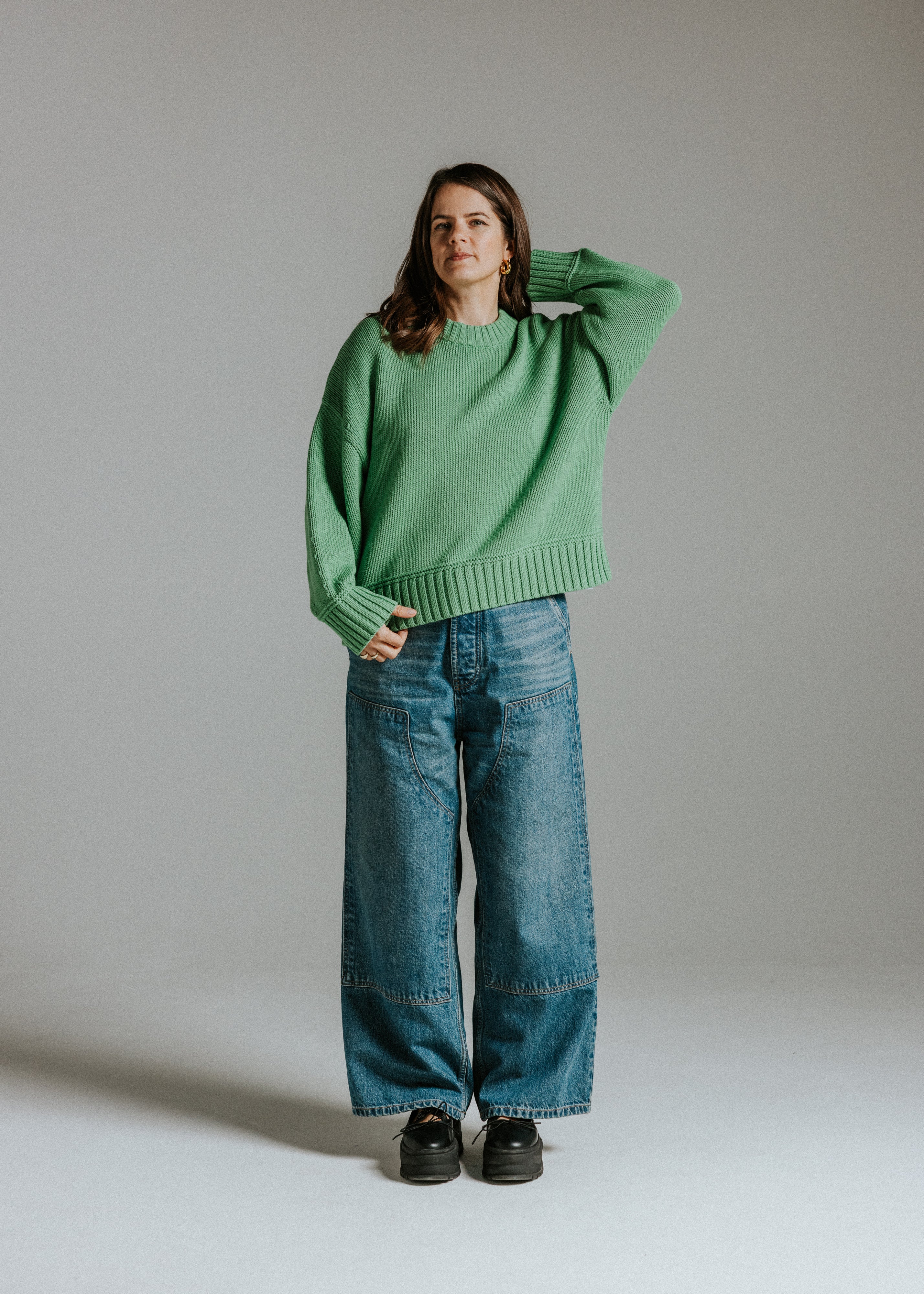Model wearing oversized boxy cotton knit green jumper with balloon sleeves by Slow Love Knitwear