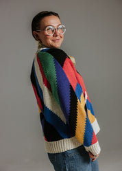 Side view of oversized handknit cotton cardigan by Slow Love Knitwear with seven colour intarsia stripe pattern