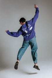 Model wearing oversized faded indigo and white smiley face cardigan by Slow Love Knitwear