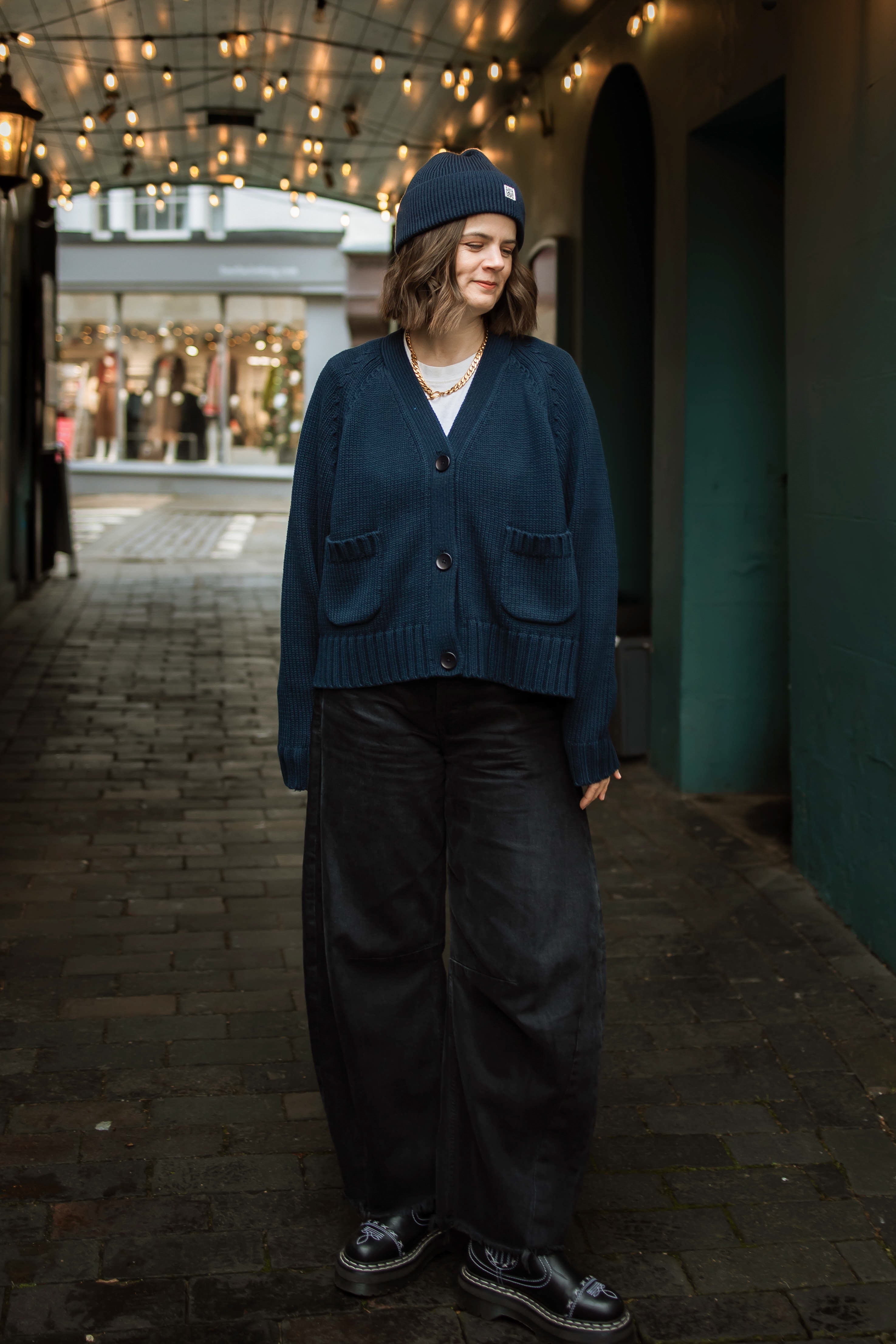 Woman wearing Slow Love's 100% cotton staple cardigan in navy. 