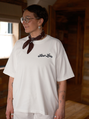 Model wearing an off white Slow Love Script oversized boxy t-shirt with a relaxed fit.