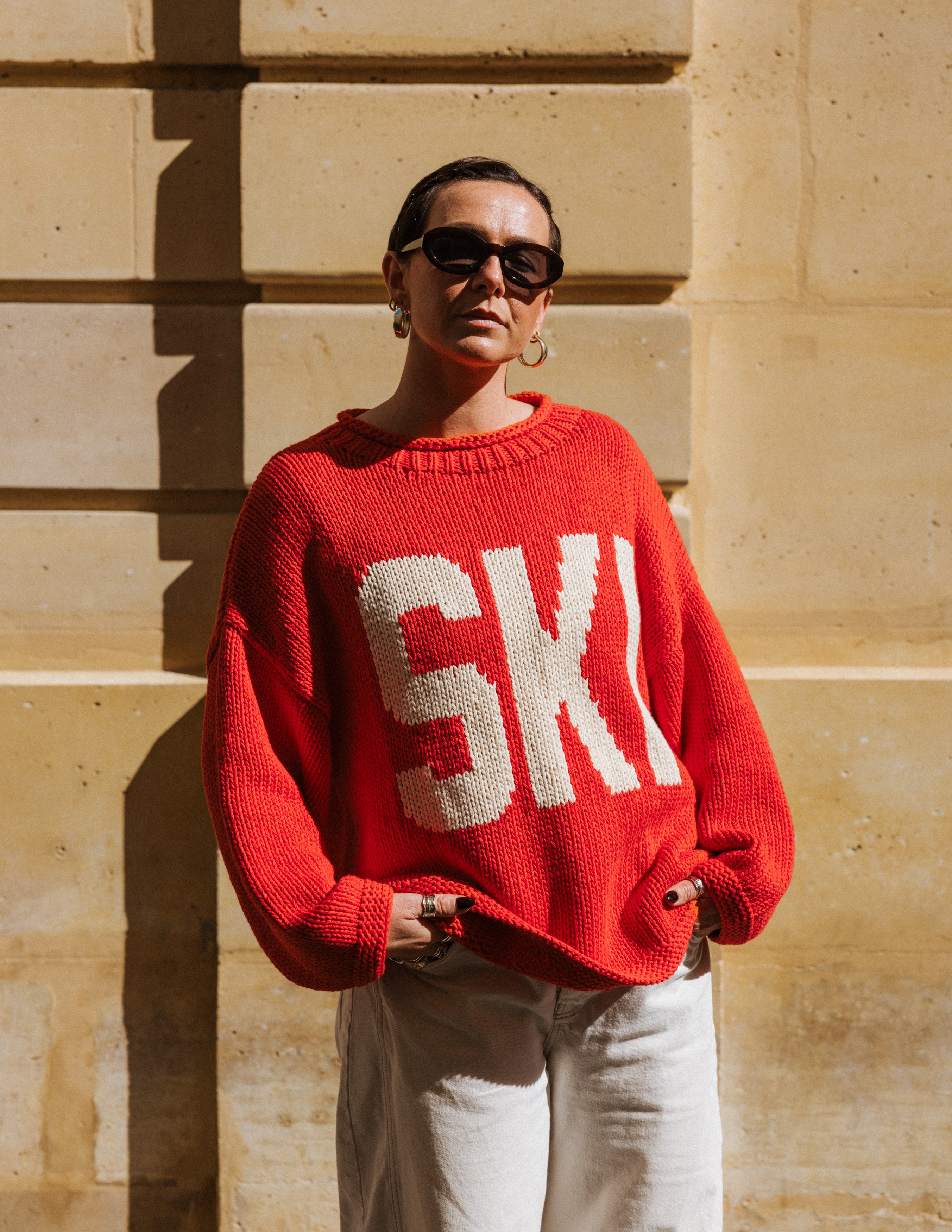 Detail of the 100% cotton knit of The Slow Love Ski Season Jumper, featuring a bold red base and contrasting off-white alpine motifs.