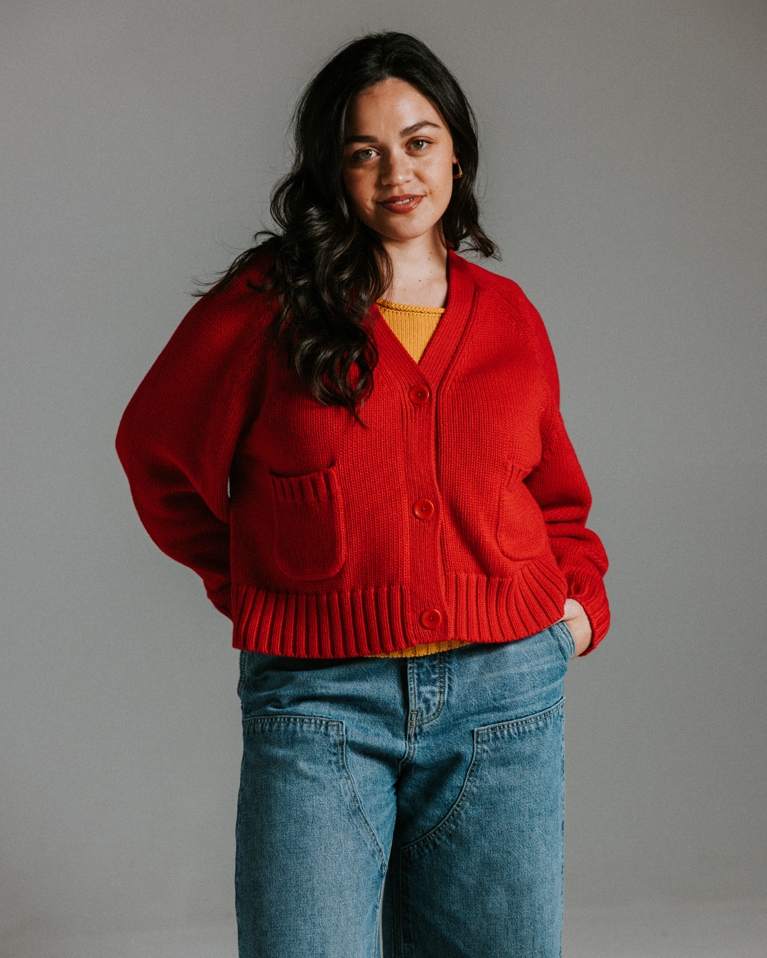 Close-up of red cotton knit cardigan showing textured knit and buttons