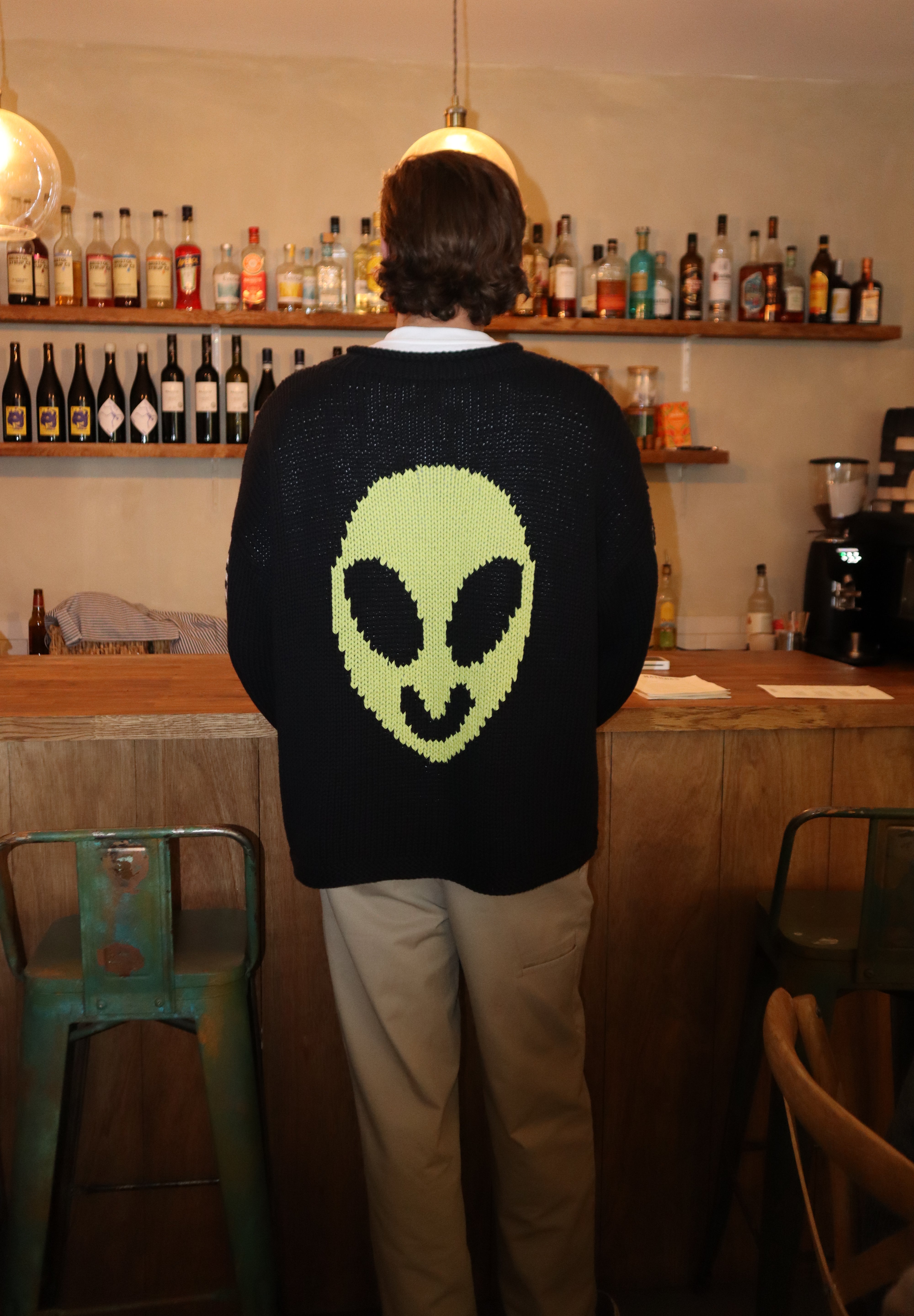 Close-up of alien motif on hand knit jumper showing knit detail