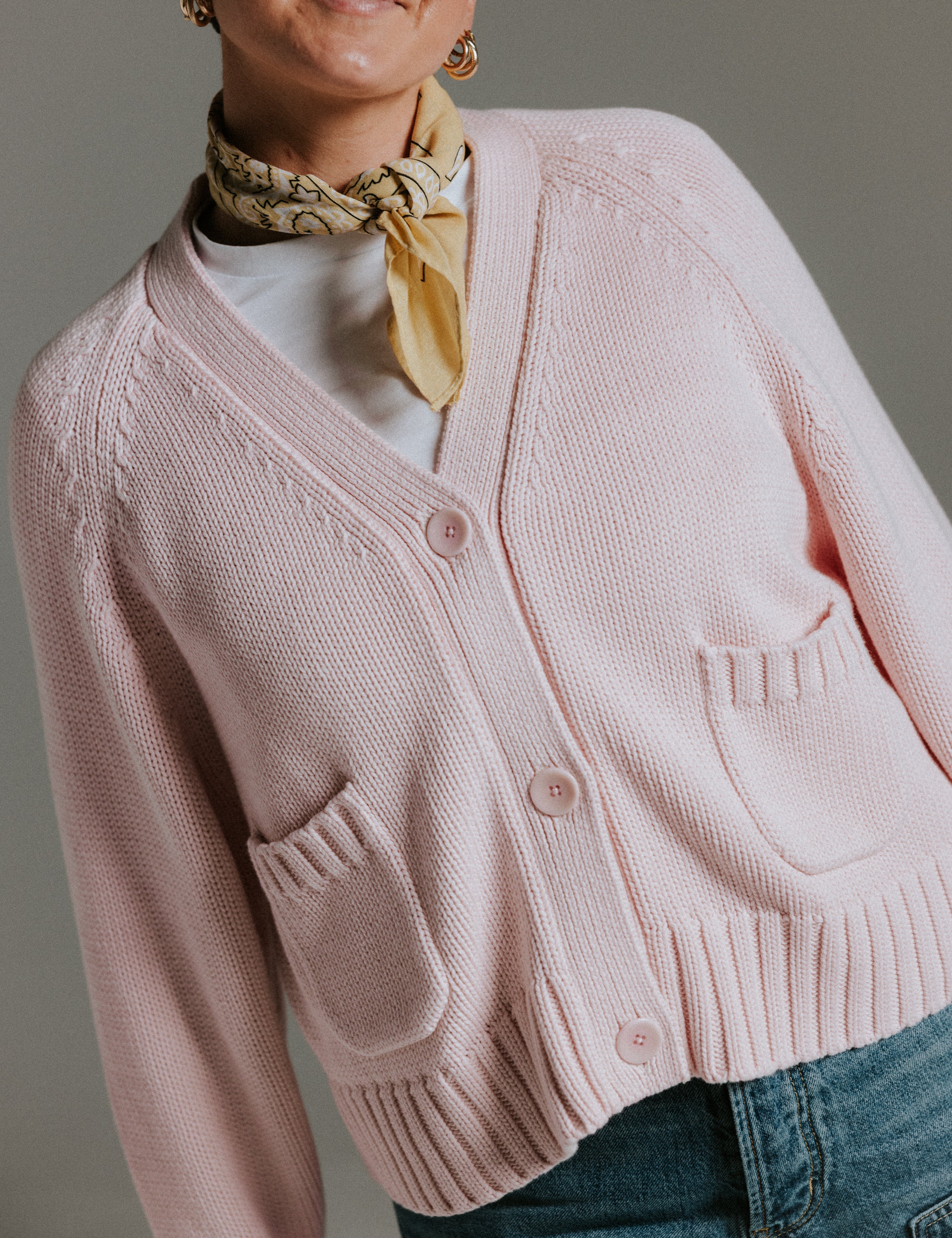 Detail of colour matched palm nut buttons on The Staple Cardigan in mallow pink cotton knit