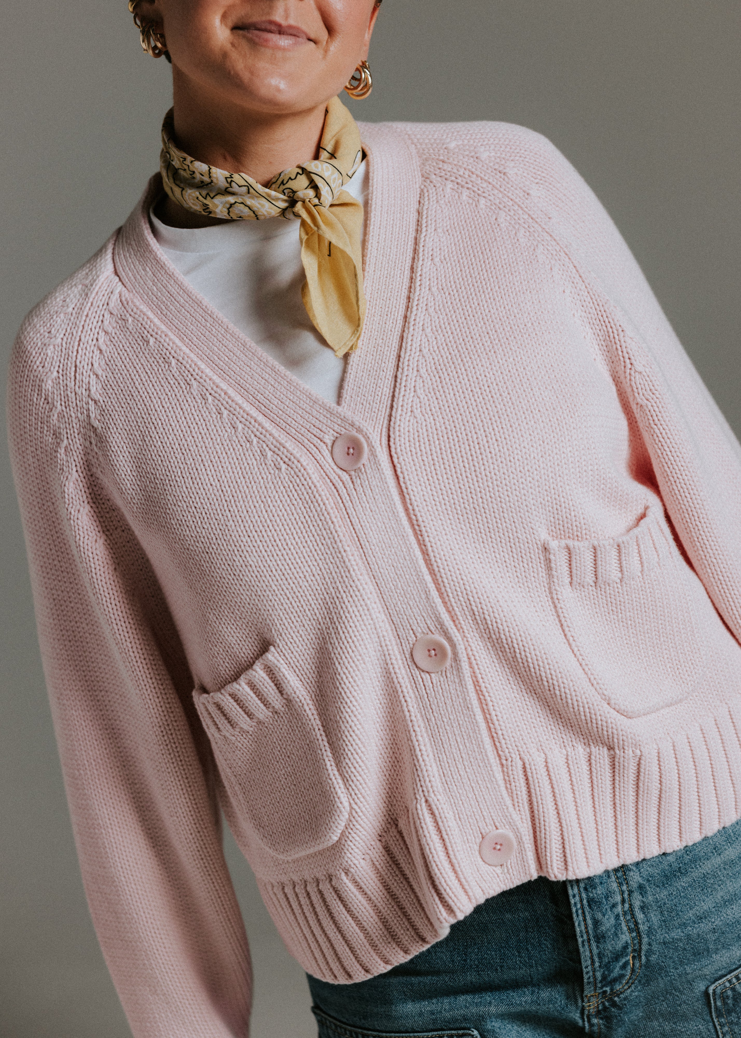 Detail of colour matched palm nut buttons on The Staple Cardigan in mallow pink cotton knit