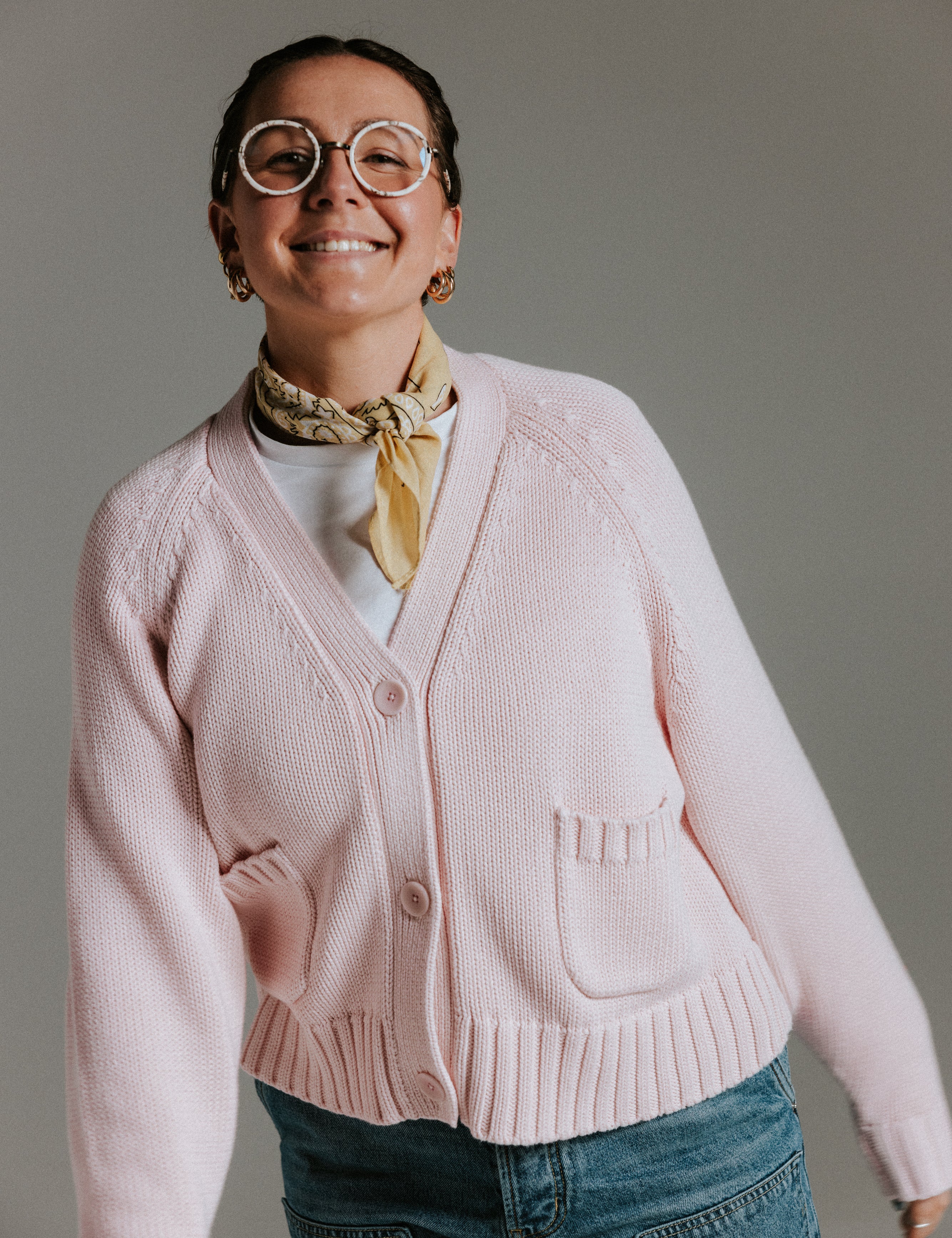 Model wearing The Staple Cardigan in mallow, a relaxed pink cotton knit cardigan with a slightly cropped fit