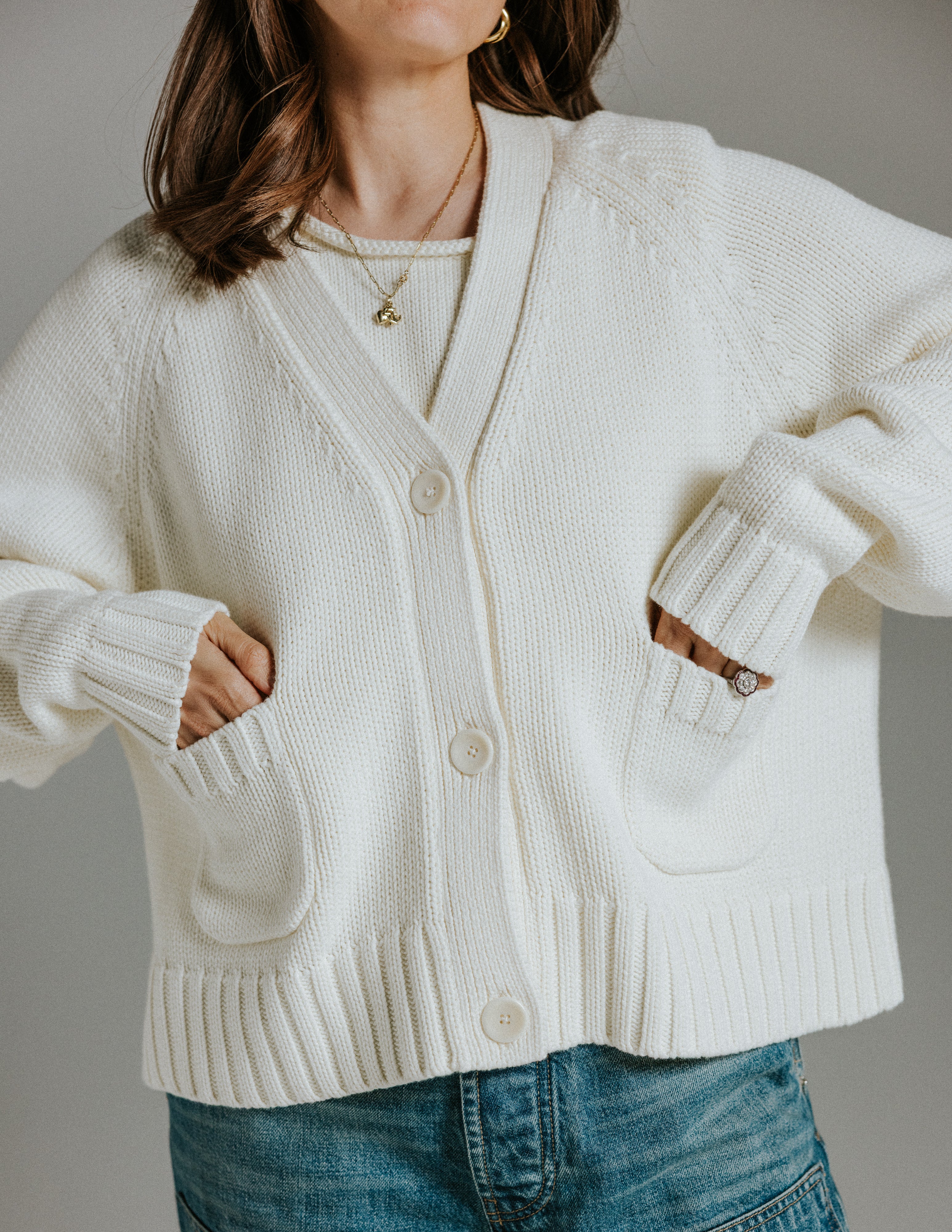 Model wearing The Staple Cardigan in panna cotta, a neutral cotton knit cardigan with a relaxed boxy fit
