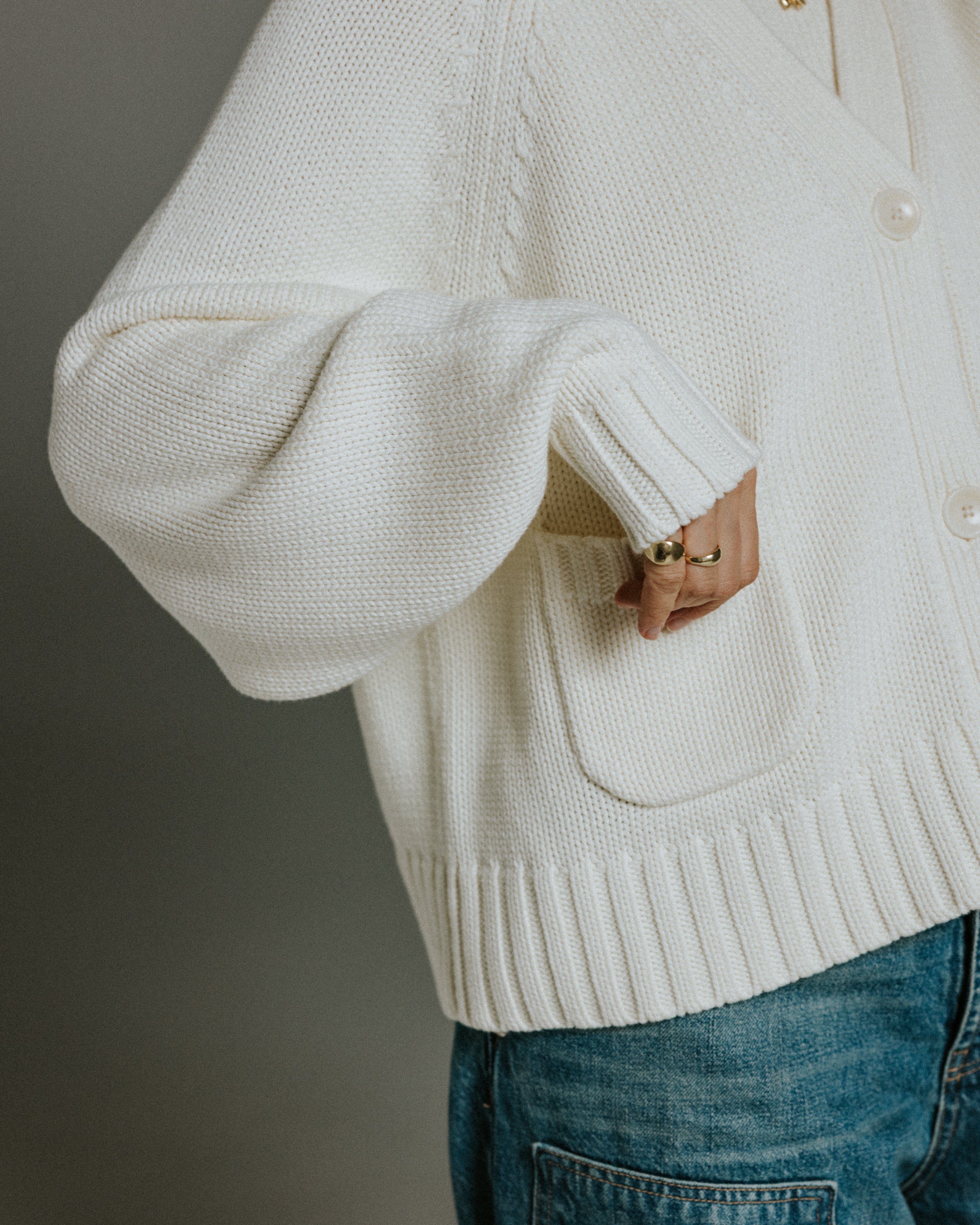Side view of panna cotta cotton knit cardigan showing cropped length and boxy silhouette