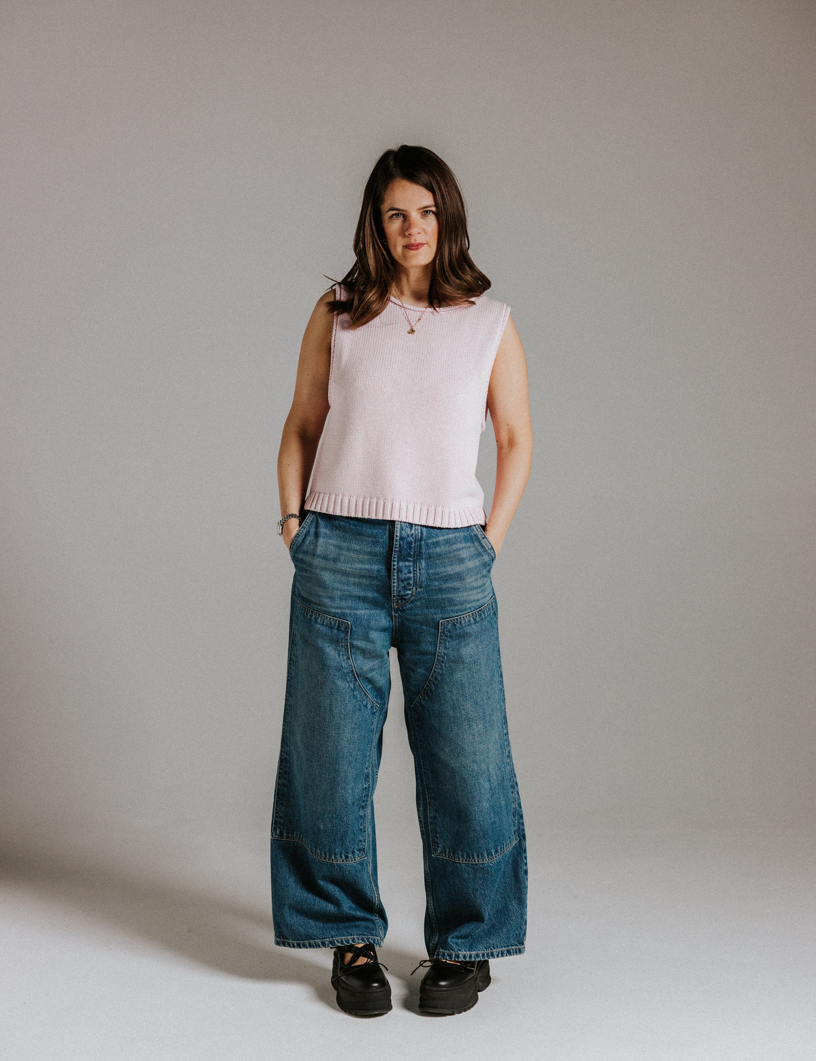 Model wearing The Staple Tank in mallow, a sleeveless pink cotton knit top with a relaxed fit