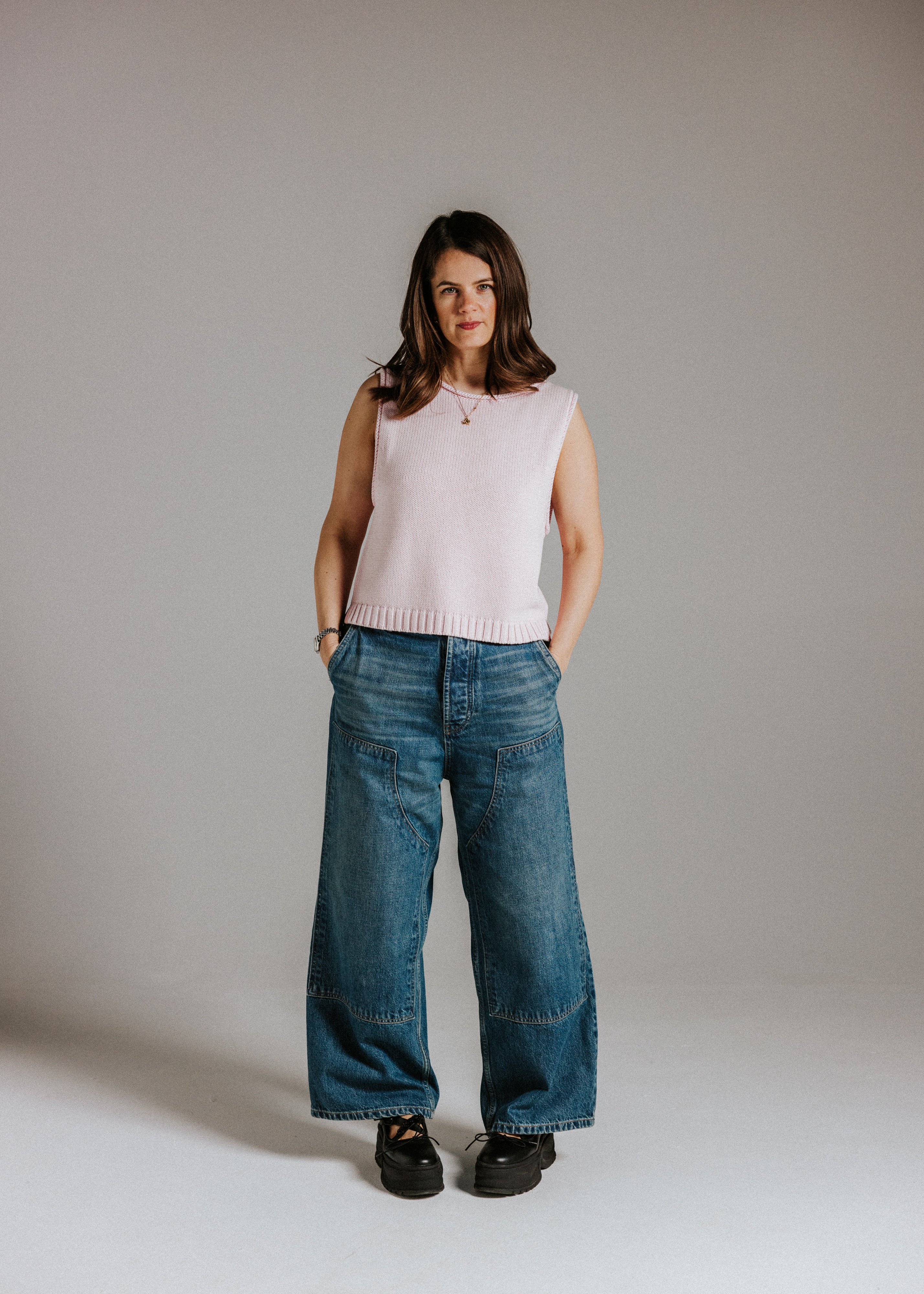 Model wearing The Staple Tank in mallow, a sleeveless pink cotton knit top with a relaxed fit