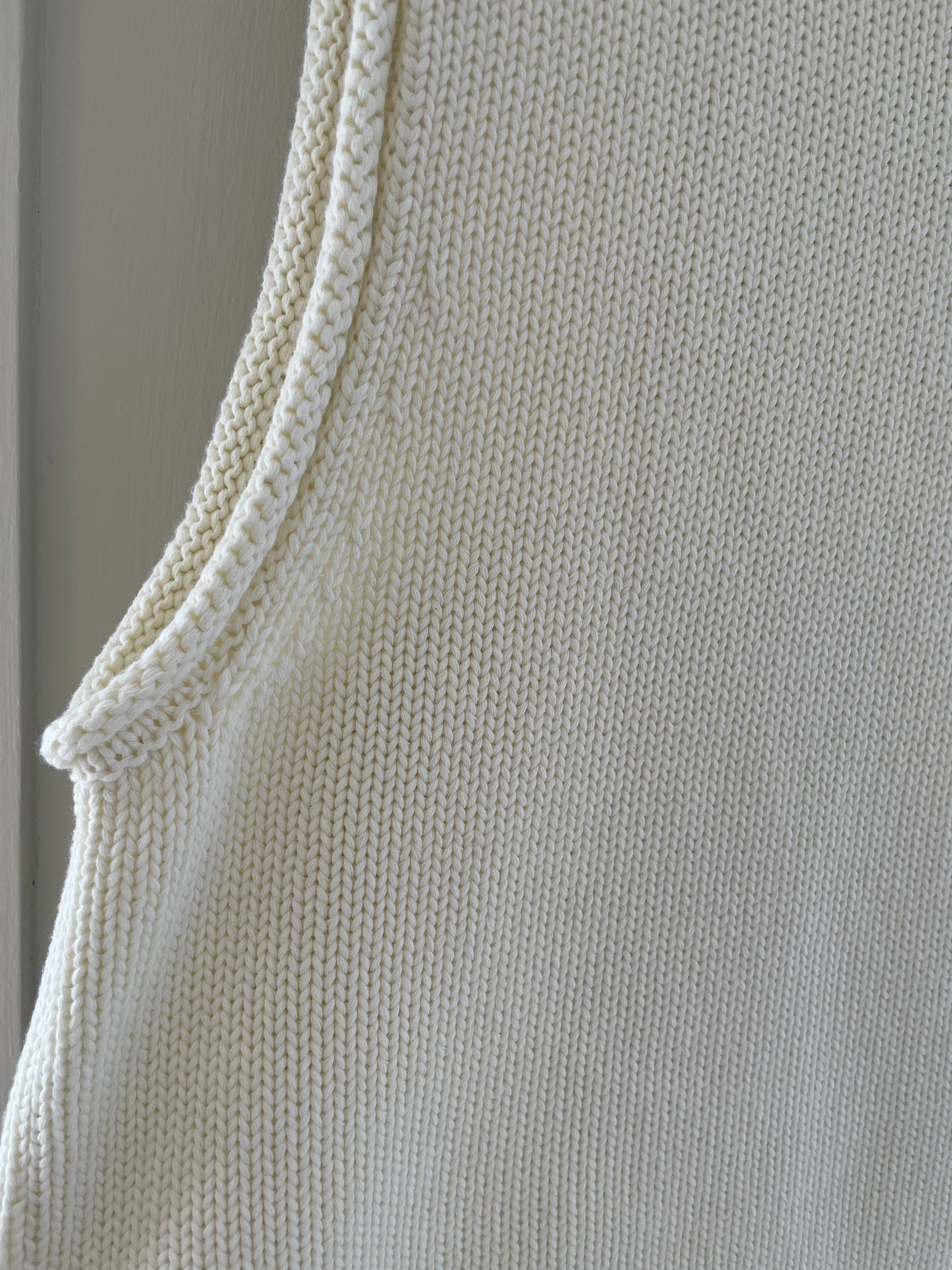 Close-up of armhole and sleeveless cut on panna cotta knit tank top